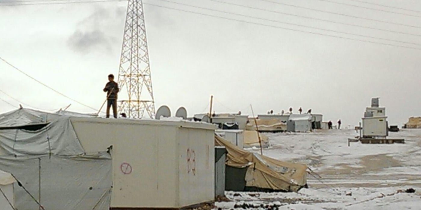 A Syrian boy playing with snow on top of a caravan the Zaatari Refugee Camp in Jordan on January 8, 2015. Photo by Faris Mismar