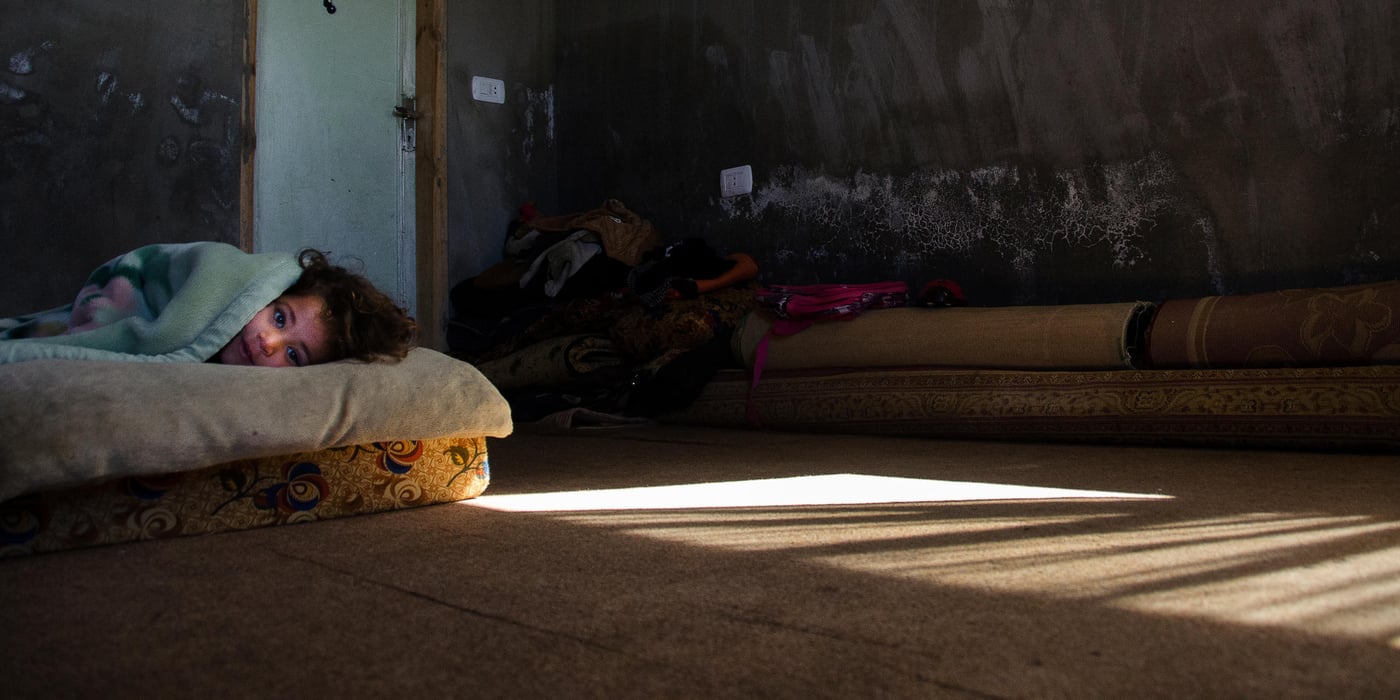 Ghazal, 4 years old, wakes up after her afternoon nap in her home in Irbid, Jordan. She lives with her sister, mother and grandmother. They fled Syria in the beginning of 2014 and moved to Jordan. Jordan now hosts close to 630,000 registered Syrian refugees, the equivalent of some 10% of its population. Syrian refugee families in Jordan, many now in their third year, face a daily struggle to meet their basic needs, access services and stay safe. Photo by: Alisa Reznick, March 2015