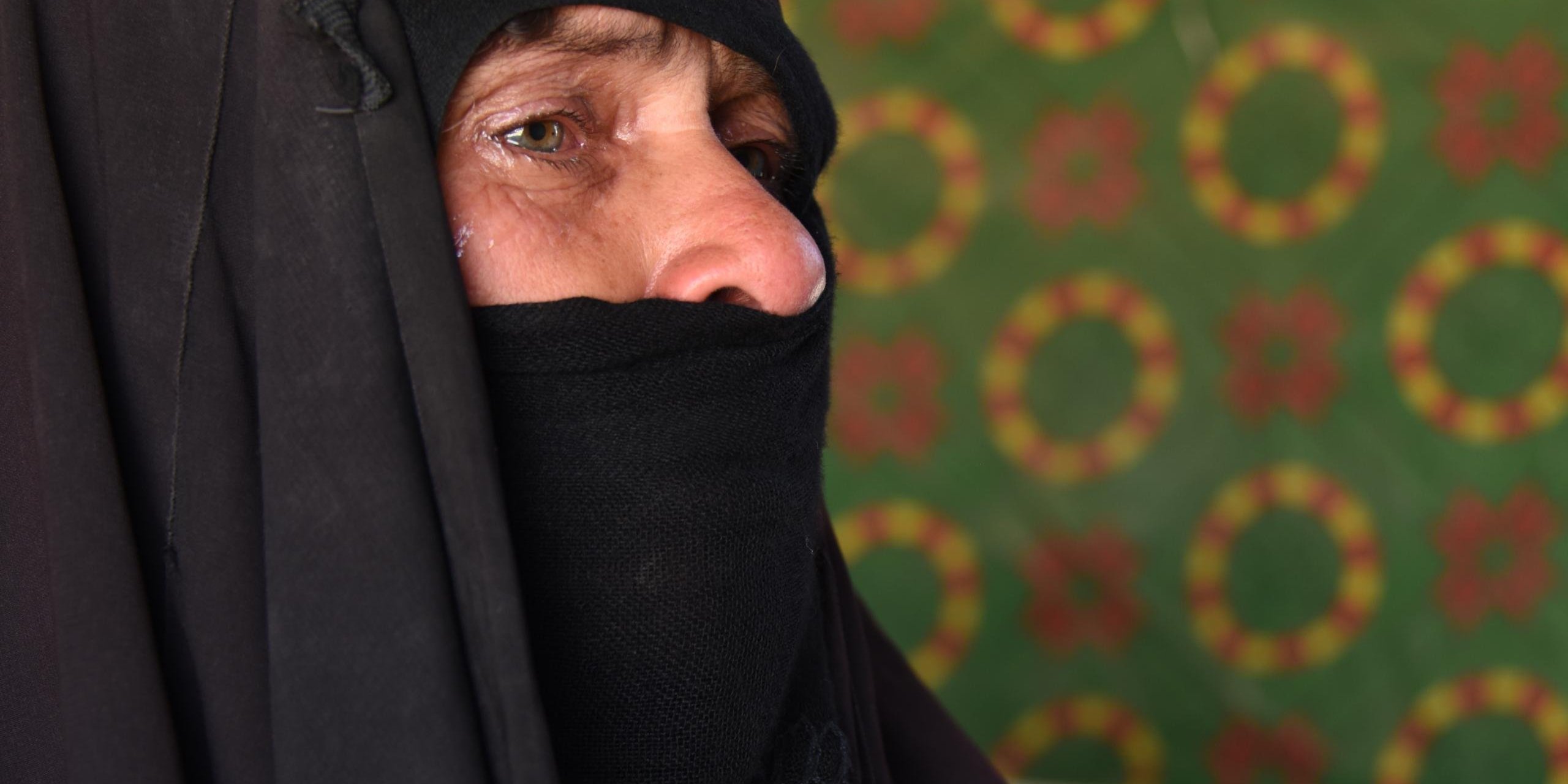 Nuriya in the Amariyat Al Fallujah Camp. 11 June 2016
Nuriya’s family witnessed a terrible tragedy as they tried to cross the Euphrates River to flee from Fallujah. Three of her grandchildren, two girls aged 16 and eight and a boy aged five, drowned in the river, while two of her sons—one of them the father of the three children—were unable to cross and she has lost contact with them.
Nuriya in her own words:
“We stayed in Fallujah’s city centre after it was taken over by ISIS. At first it was bearable, but then hunger started to hit us.
“They stopped us when we first tried to leave at the beginning of the military operation, so we were caught in the crossfire. We escaped 10 days ago under cover of darkness until we reached the river bank. We stayed there for two days without food until we managed to cross with other people. It was total chaos.
“I was on a boat ahead of the rest of my family. When the boat I was on reached the middle of the river I heard a lot of screams, another boat was sinking. People were shouting, ‘Save us, save us’. People jumped from the other side of the river and saved some of those who were drowning, but not my son’s two girls, aged 16 and eight, and his boy aged five. Their mother was holding on to two of them; one of them was still alive, the other one was already dead, until she lost them. We couldn’t see the girls, we only found their bodies later far away near Bzeibez Bridge. I was shouting, ‘Where are the girls?’, but they told me they had drowned.
“Four children were rescued from the river, but not my son’s two girls and boy. The soldiers took us away; one of my daughters-in-law was in critical condition. They took her to hospital.
“I called my son and told him that his son had drowned, together with his two daughters; that we had found his son’s body but not his daughters’. He told me frantically to go back, everyone, dead and alive, we should all go back to him. I told him I couldn’t go back. I couldn’t. We’d die of hunger. ‘Return back,’ he insisted. ‘Both the dead and the alive’. I couldn’t even return his dead children to him. If we went we’d die of hunger, mortars and shelling. His poor children drowned hungry—they hadn’t eaten in two days.
“My son remained there, he couldn’t cross, together with another son of mine. Now I’ve lost contact with them. I don’t know what happened to them, but I can’t go back to them. We’d die of hunger if we go back.”
Photo: Karl Schembri/NRC
