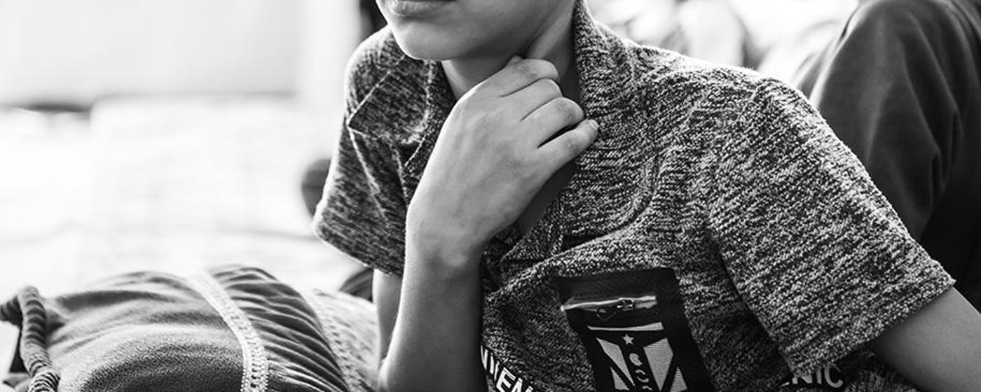 Black and white portrait of Mohamed, a 13-year-old boy from Syria. He has a large scar across his forehead and left eyebrow. 