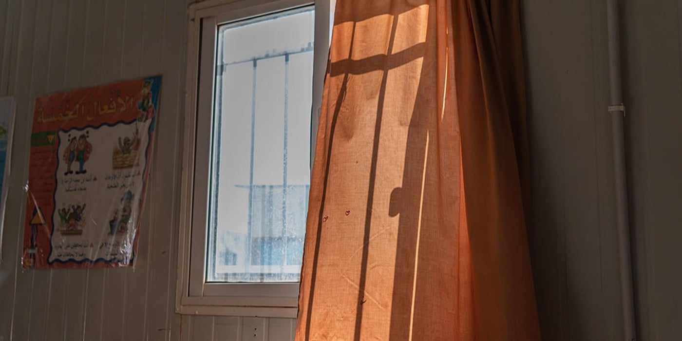 A curtain gently blowing in the wind from an open window.