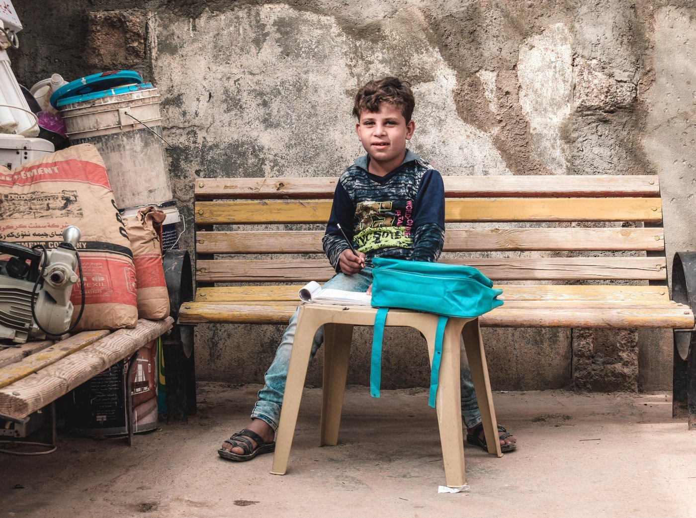 Mohammed; 8 from Al Qa'im; is going back to school for the first time since the retaking of the city from Islamic State group.

Mohammed could not go to school for the past 4 years when Al-Qai'm was under IS rule.  His parents wouldn't allow him to go and learn about violence in IS group schools. They were afraid that their child would be brainwashed and join them. 

IS group members used to throw Mohmmed to the air and bully him.  As a result, Mohammed got traumatized and stayed home all the time. He would go outside the house only accompanied by his parents.

After the retaking of Al-Qa'im, Mohmmed had difficulties overcoming his fears. He was still afraid and used to cry every time his parents would send him to school. When he met NRC education team, they helped him to deal with his trauma and manage his stress. 

One of NRC's incentive teachers says: " it was not easy to build trust between Mohammed and us, we had to be patient, sometimes we were visiting and teaching him at home until he got used to us and trusted us".

Mohammed's mother says that without NRC summer courses, Mohammed wouldn't have been able to go back to school and communicate normally with people again. Now after attending NRC summer school, my son loves school and dreams of becoming a doctor in the future".

Photo and Caption by: Helen Baker / NRC