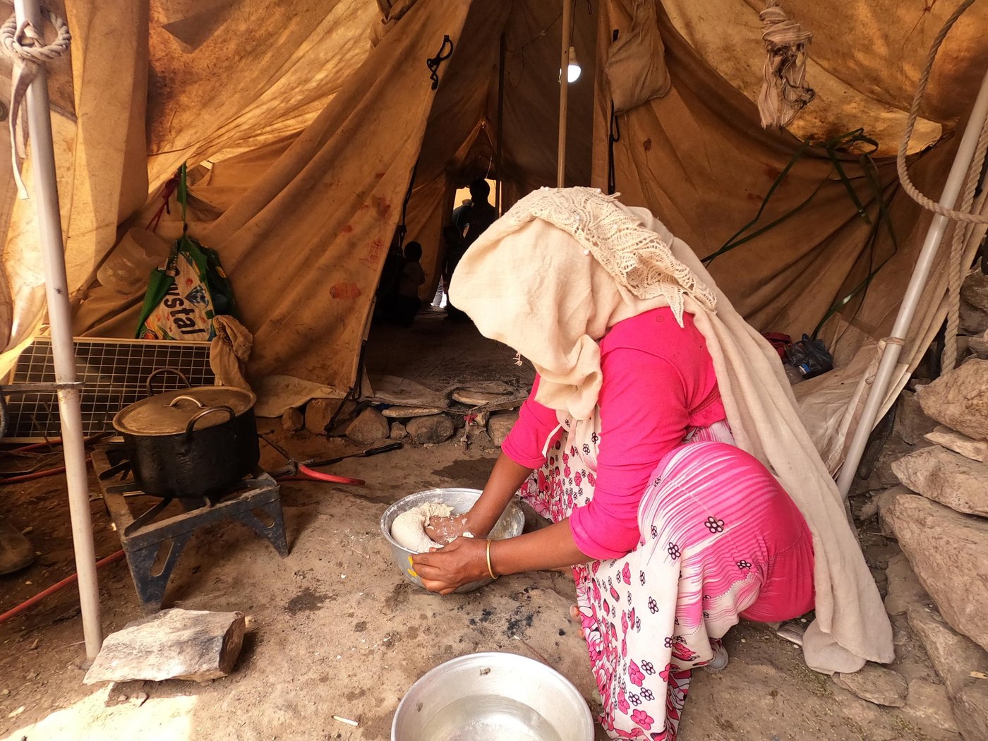 Ahmed's wife prepares the lunch for the family inside her tent in Al-Malika camp in Taiz.

Photo: Khalid Al-Banna/NRC