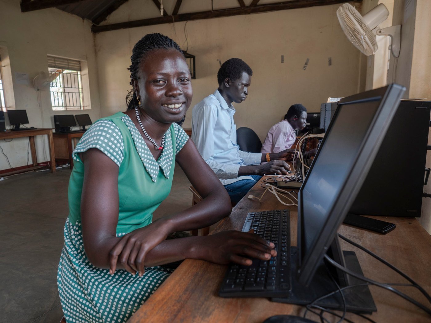 Adau (24) fled from South-Sudan in 2014 with her mother and sister. She was out of school for five years but have now completed the online training course. She is waiting for her enrolment at the Kampala University. Adau is dreaming of pursuing a carrier in social network.
Only 3% of refugee youth have access to tertiary education, compared to 36% of the world’s youth. While a growing number of programmes provide tertiary education opportunities to refugees through scholarships and distance education these are few and with little documentation about processes and outcomes. The partnership between. Arizona State University (ASU) and Norwegian Refugee Council (NRC) is a direct response to this need.
In August 2018, ASU and NRC signed a Memorandum of Understanding to establish an ASU Earned Admission programme at Ayilo and Nyumanzi refugee camps in Adjumani District, Uganda. The programme provides students with access to online courses through the university’s Global Freshman Academy.
25 South Sudanese and Ugandan learners participated in the programme. 40% are female and the makeup of the group otherwise reflects the importance of working hand-in-hand with the host community.
Location: Youth Center in Nyumanzi Settelment, Adjumani, Uganda
Photo: Ingrid Prestetun/NRC