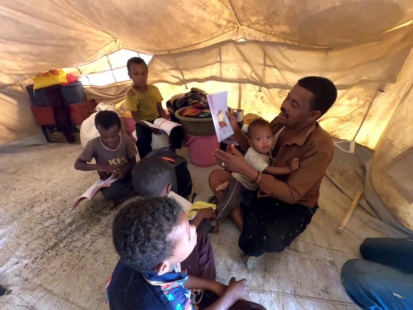 Ahmed teaches his children in their tent in Al-Malika camp in Taiz, after the closure of the schools because of Covid-19.
Photo: Khalid Al-Banna/NRC