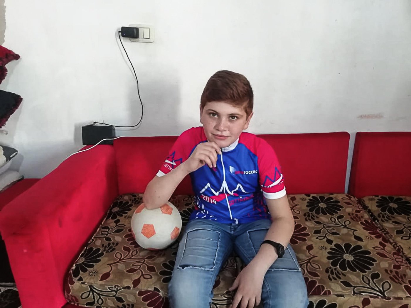 Since the outbreak of the Covid-19 the Norwegian Refugee Council (NRC) have been working around the clock to ensure that refugees and displaced children and youth can exercise their right to quality, relevant education.
Mohammad, 13, is one of these children. He is originally from Hama in Syria but fled to Lebanon together with his family six years ago. Now he lives with his parents, three sisters and three brothers in a small apartment outside Tripoli, North Lebanon.
“Although it has been six years since we arrived here, I still wish we can go back every single day. We could play football as much as we wanted in front of our home and we had a huge yard where no one bothered us,” says Mohammad. “In Lebanon we can never finish a football game, the neighbours always get annoyed and ask us to go back home. Now the situation is worse, we can’t do anything.”
Refugee children are bearing the blunt
When the activities stopped due to the Covid-19 outbreak Mohammad and his brothers were very upset. Going to the NRC learning centre, meeting their friends, and learning was part of their daily routines. “It’s not easy to stay at home, I feel down but there is nothing we can do,” says Mohammad with hesitation. 
The Corona crisis has led to closed schools and disrupted the education to more than 1.5 billion learners. Refugees and displaced children and youth are bearing the blunt. Children and young people in displacement have often missed out on years of education already, due to war and conflict, and without any help, school closures due to Covid-19 will make them fall behind even further. 
“To meet the needs of Mohammad and 1,200 other children enrolled at NRC learning centres in Lebanon we are now implementing remote learning modalities, including via communication platforms such as WhatsApp, combined with follow-up phone calls to provide guidance and support and to safely refer people to other specialised organisations,” says Rayan El Baf, one of NRC’s child protection technical officers in North Lebanon.  
Due to the lockdown and fear of spreading the virus our colleagues are not able to visits the children and their parents. It is Mohammad’s mother, Fatima, that has sent us the photos, and it is our colleagues in Lebanon that have interviewed Mohammed and his mother.
“The remote learning has benefited my children a lot. Instead of leaving them behind during this period, NRC’s remote learning methods show us that NRC continues to care about the education of our children and appreciate their efforts to learn. It helps them connect with their inner selves, it gives them courage and strength to know their own worth,” says Fatima, Mohammad’s mother.
Nationwide lockdown 

On the 15th of March, Lebanon declared a state of general mobilization in an attempt to control the spread of the coronavirus. With the nationwide lockdown, the basic survival and protection of the most vulnerable communities in Lebanon has become a critical issue. However, despite the challenges and to minimize the risk of exposure to beneficiaries and its frontline staff, NRC Lebanon continues its essential service delivery by only implementing critical lifesaving activities on-site and has tailored other programme interventions through different modalities to specifically support the national Covid-19 response.  

Stay and deliver
“Although our learning centres were closed due to the Covid-19 situation, we never stopped delivering educational messages to the children,” says Rayan El Baf. “We regularly contacted them and their parents over the phone to check on their wellbeing, raise awareness on the situation and share learning materials,” she says.  
Since the coronavirus lockdown, Mohammad spends most of his time at home. He either focuses on the NRC learning materials, revises the lessons, or plays with his siblings. He also sometimes helps his father at work, who sells coffee for a living.  

Caring teachers

“My teacher Rouwayda always supports us to solve the exercise when we need help. She is caring and fair. Our teachers make us feel at ease and insist that we understand the lessons before leaving the classroom,” says Mohammad.  

Mohammad’s mother is grateful for the support NRC gives her children. “They are always so happy when talking to the staff and are able to express themselves easily.”

“The remote teaching allows my children to revise and remember the information they received in the classes and bring some variety to the daily routine during the coronavirus lockdown. This is not only helping them to learn but also to feel more positive about the situation,” Fatima says. “The remote learning and support given over the regular calls also helps me to communicate better with my children”, she concludes.  

New ways and solutions 

“Though adopting remote learning modalities, we have been able to develop a positive bond between us and the parents are becoming more involved in their children’s education. Luckily, we have not faced any difficult issues with the remote learning, and we are always trying to find new ways and solutions to deal with any challenges that might arise. However, the hardest challenge is perhaps that we cannot answer the children when they ask us when they can come back to our centres to see us and their friends,” Rayan concludes.  
 
“The learning centre was a place where I felt safe. I miss both my friends and the teachers. But most of all I would like to return to Syria,” Mohammad says. 
Photo: Private