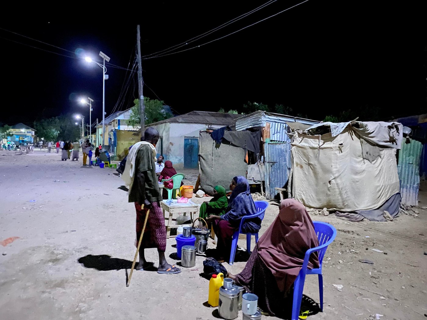 Hudur is a town in the south western Bakool region of Somalia. It serves as the province’s capital and is the center of Hudur town. The main supply routes to and from Hudur town are blocked and are controlled by Al Shabaab. For the last seven years, food and other commodities were transported only by donkey carts but in the last two months, the situation was getting worse.
All roads leading to the main towns of Baidoa, Mogadishu and Beletweyne remain blocked, and no goods are allowed into the Hudur town. The Means of transport available to traders and consumers is airlift resulting in high transportation costs, which further adds the cost of goods to the consumers. The scenario contributed to scarcity and high commodity prices. Rainfall harvesting is a significant source of freshwater to Hudur residents: as such, below average GU rains leading to low crop yields and drying up of (Warcadey and shallow wells), means the situation is fast deteriorating.
According to local authorities and PRMN reports, an estimated population of 4,950 households, comprising 29,700 individuals, are confirmed to have fled their homes mainly from the peripheries of Hudur town. The displaced households were unable to take their belongings and essential household assets. A significant portion of the affected populations were older people, children, pregnant and lactating women, and persons with disabilities, observed mainly arriving on foot or by donkey.
Currently, there are 20 active IDP sites hosting 9,263 households or 55,578 individuals. Compared to the last site verification conducted in April 2021, there was an increase of 3 IDP sites, 4,950 Households or 29,700 individuals. The projected number of people expected to face crisis of (IPC Phase 3 or higher) and would require urgent humanitarian assistance in Hudur for the period July to September 2021 is 21,300.
Hudur town, is under complete siege. The supply routes to and from Hudur town which are blocked and are controlled by Al Shabaab. Food and other commodities are transported by only air which further escalated the price of the commodities to the consumers. Hit and run attacks to the town mainly during night hours, occur and the residents were observing a rehearsal of a big AS attack to the town. For two consecutive years, the livestock and agricultural productivities has been below normal in many parts of Bakool region due to poor rangeland conditions and below-average rainfall, leading to low income from livestock sales and limited household availability of livestock products and local cereal stock.
Most rangeland areas have received below-average rainfall amounts during the last Gu season. The current dry conditions are expected to aggravate the already poor malnutrition status within the Hudur district of Bakool region. There is persistent food insecurity among IDPs and vulnerable host communities in Hudur district with limited operational presence of humanitarian agencies in the area.
A quick solution was needed to respond to this desperate situation, so in 2020, the Norwegian Refugee Council (NRC) implemented the project “Integrated protection response to vulnerable and displaced populations in Hudur district.” This was funded by the Somalia Humanitarian Fund (SHF), and involved in both WASH and protection activities. The WASH facilities has made a huge impact and provided free and safe drinking water to over 13,500 individuals.
Muslimo Abdi Ibrahim, and her family of nine children (3 boys and 6 girls) have been living in Dondardid IDP camp since fleeing from their village in the rural areas outside Hudur. Due to the lack of sufficient water, to save water for only cooking and drinking, Muslimo said that they had to limit the bathing times. They used to take bath only two times a week.
She also said that water was very important for themselves and they needed water more than anything else in their life. Thanks to NRC’s immediate response, Muslimo and the other vulnerable IDP communities in Dondardid camp are no longer to worry about water. They can now access water effortlessly.
“We have free and safe drinking water in our doorstep. I can comfortably fetch enough water. My family can use water for drinking, cooking, washing clothes and bathing. Nothing to worry about at the moment,” she said.
Seven years down the line, since the siege, the communities in Hudur district could not walk the streets at night due to darkness and fear. All business along the main and small streets in the town closed at 5:00 pm in the afternoon. No movement. No social-gathering at all, and the residents locked themselves up in their homes.
“After the sunset, everyone goes home. People could not walk anywhere in the town specially women because of fear. Everything can happen under the cover of darkness, so we remained home,” says Habiba Ali Borow, a local resident in Hudur district.
The Norwegian Refugee Council (NRC) rehabilitated thirty-two solar streetlights in one of the main streets in Hudur district. This was part of NRC’s integrated project funded by the Somalia Humanitarian Fund (SHF). Life for local residents changed since the rehabilitation of the solar streetlights. They are now doing business and socializing on the streets after sunset.
“After years of fear, and being in darkness – the main street has been illuminated. The darkness is over now. When the lights started working. We felt like we get out of a prison, we can walk freely at night to shop or visit friends, relatives and neighbours without any fear,” she said.
Ruqiyo Ibrahim, a mother of seven, and the owner of sells milk along the main street, has seen her small business doubled since the solar streetlights were rehabilitated. Business along the main street including shops, restaurants and small business can now stay open at night as long as there are people who want to shop. It’s a huge blessing to have the solar streetlights and the lighting scheme provided opportunity to all the people.”
“Young people are enjoying tea in outdoor tea-shops because of the solar streetlights. Children are also playing football along the side of the main street, and we thank NRC and SHF for that” said Ruqiyo.
Text: Abdulkadir/NRC
Photo: Abdulkadir/NRC