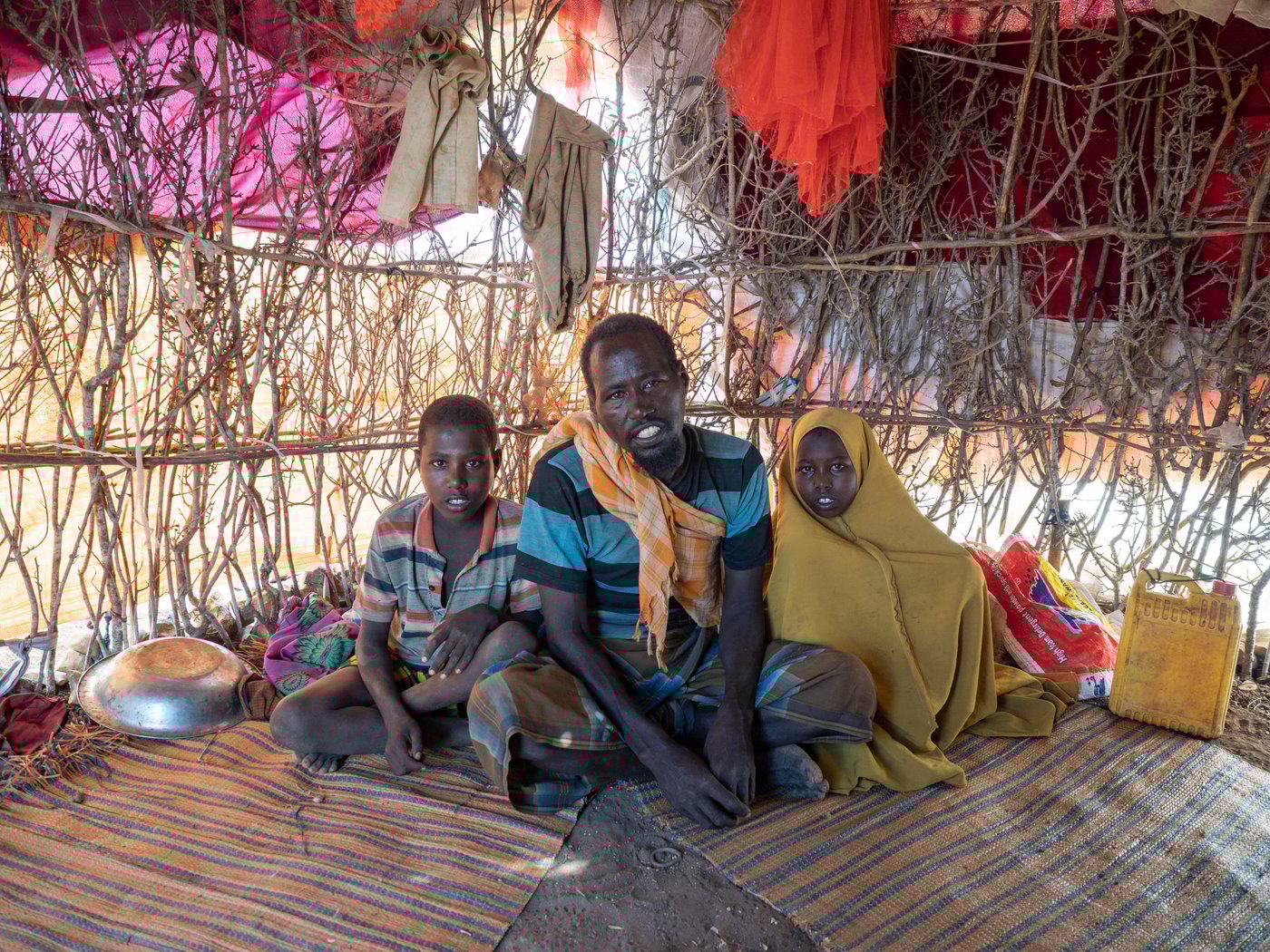 Hassan Mohamed Abdi, 45, is a widower who lived as a farmer until recurrent drought over several years made it impossible to sustain his family. Hassan and his four children now live in a small shelter in the Ceel-ilaan displacement camp, outside Baidoa.
“Over the four years this drought has lasted, we have planted on our farms and the harvest has given no result. For a while we survived by working for others. We decided to flee to the city because we couldn’t continue living in the village on account of the drought. That is why we came to the city, to ask for assistance from the humanitarian organisations.”
Like many people displaced to Baidoa, Hassan was forced to flee to assistance because insecurity prevents humanitarian assistance from reaching his home area.
The two children in the photo:
Kulmiyz, 7 years old.
Halima, 5 years old.
Photo: Ingrid Prestetun/NRC