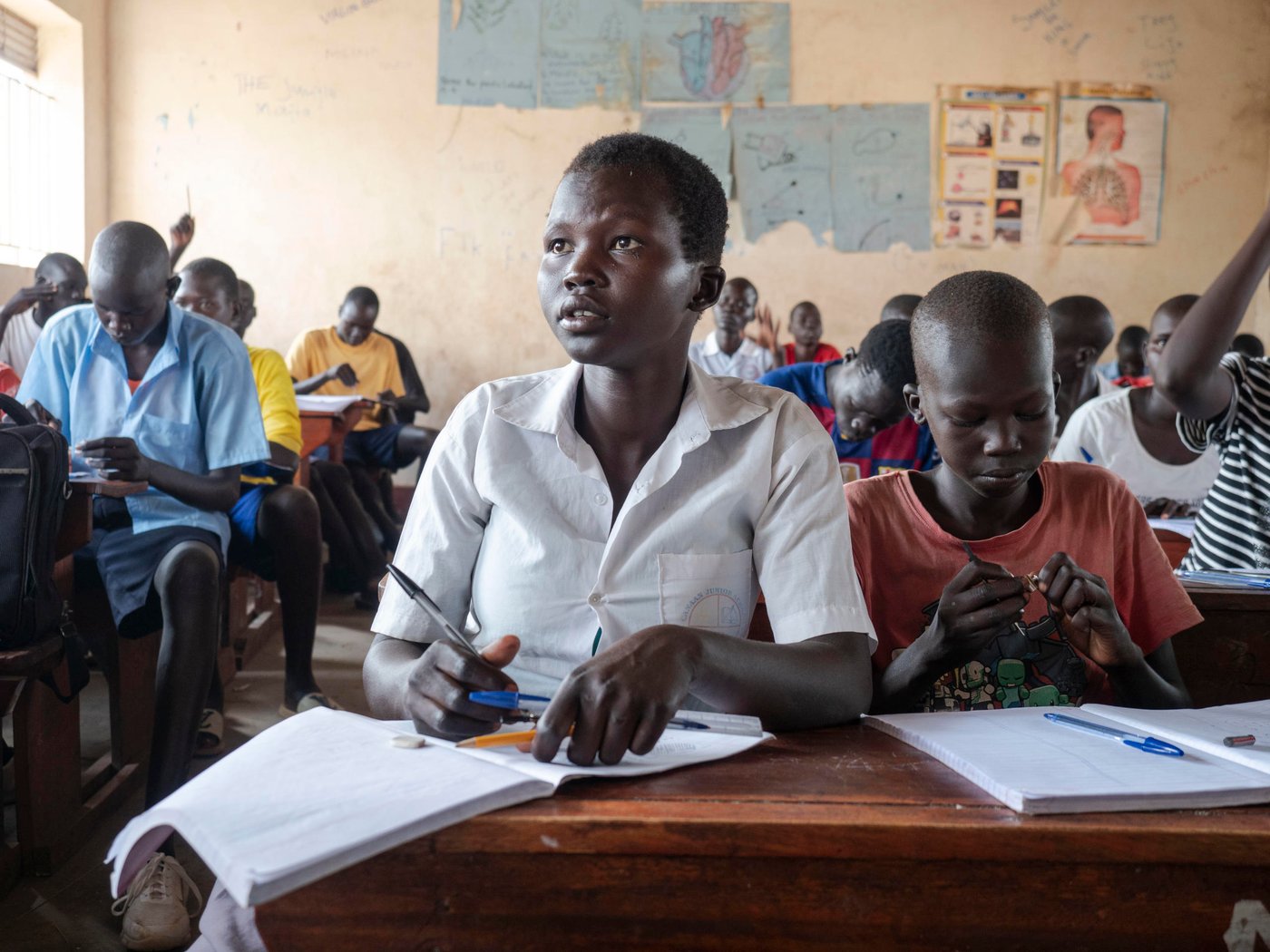 Athieng (20) student at the Accelerated Education Program in Nyumanzi, Adjumani District. Athieng fled from South-Sudan to Uganda in 2015 with her two brothers and mother, after first staying 2 years in Kenya. They live 25 km from the border to South-Sudan.
In Nyumanzi Settlement in Adjumani, Uganda Athieng gave birth to twin daughters in 2019 and her mother is taking care of them while Athieng is in school. Her father is still in South-Sudan.
Athieng is now attending last year of primary school in NRCs Accelerated Education Program. She and her 14 year old brother is attending the same class. AEP in Nyumanzi has more than 200 students from the age of 10 to 20 years. Athieng has a dream to become a nurse in the future.
Location: Youth Center in Nyumanzi Settlement, Adjumani District, Uganda
Photo: Ingrid Prestetun/NRC