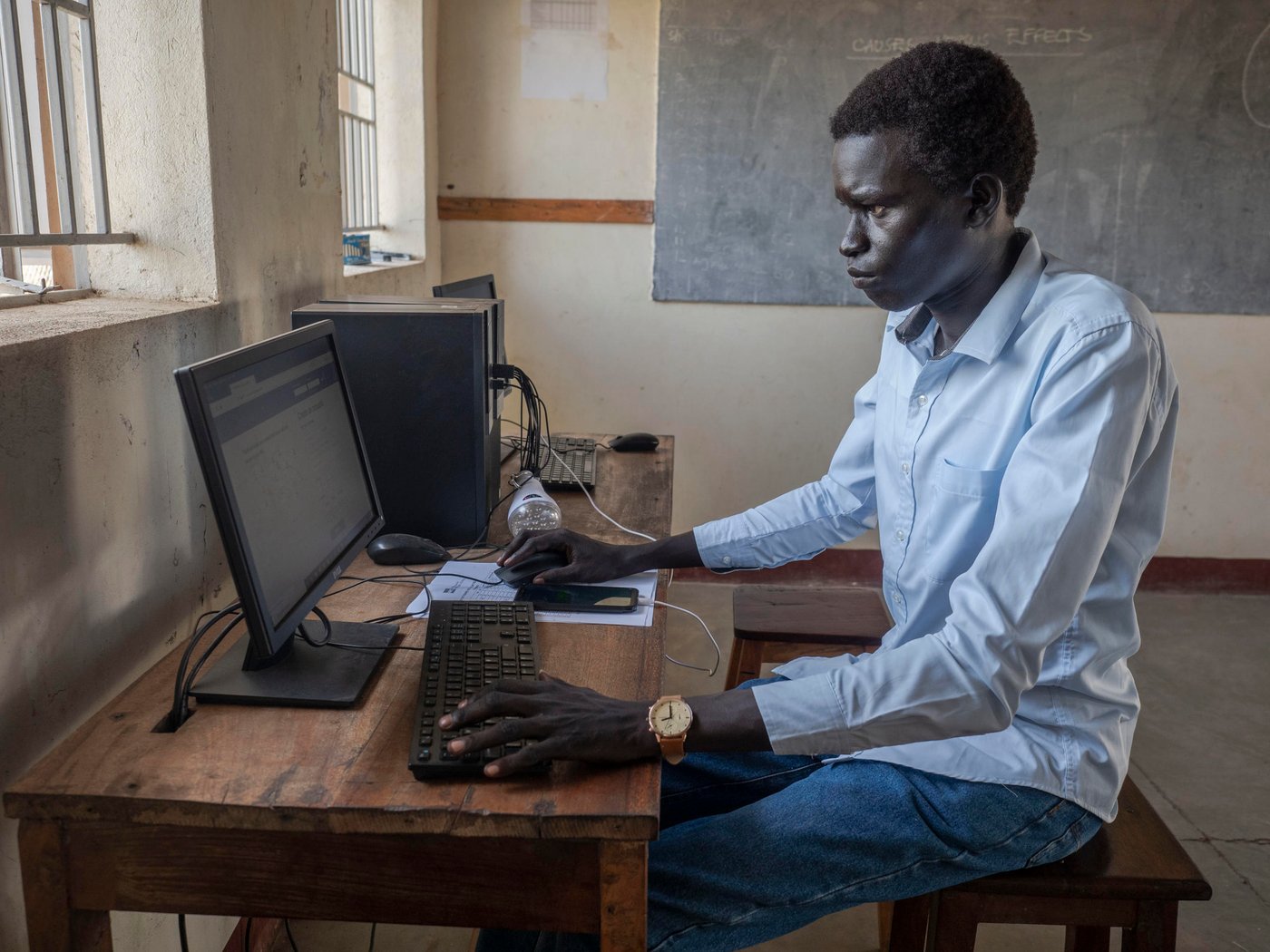 David fled from South-Sudan ti Uganda in 2014. He completed high school at a local school in Uganda. He as now finished the online training course and a waiting for his enrolment at the University in Kampala. David is dreaming of doing an exchange year in either the United Kingdom or the United States. He want to pursue a carrier in software engineering to secure his future.
Only 3% of refugee youth have access to tertiary education, compared to 36% of the world’s youth. While a growing number of programmes provide tertiary education opportunities to refugees through scholarships and distance education these are few and with little documentation about processes and outcomes. The partnership between. Arizona State University (ASU) and Norwegian Refugee Council (NRC) is a direct response to this need.
In August 2018, ASU and NRC signed a Memorandum of Understanding to establish an ASU Earned Admission programme at Ayilo and Nyumanzi refugee camps in Adjumani District, Uganda. The programme provides students with access to online courses through the university’s Global Freshman Academy.
25 South Sudanese and Ugandan learners participated in the programme. 40% are female and the makeup of the group otherwise reflects the importance of working hand-in-hand with the host community.
Location: Youth Center in Nyumanzi Settelment, Adjumani, Uganda
Photo: Ingrid Prestetun/NRC
