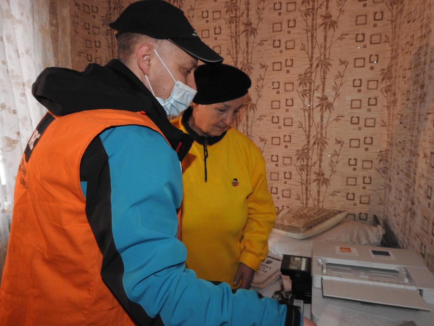 Maksym Holtvianytskyi, a technical officer with NRC, helping Valentyna to use the new equipment. Photo: Violetta Shemet/NRC