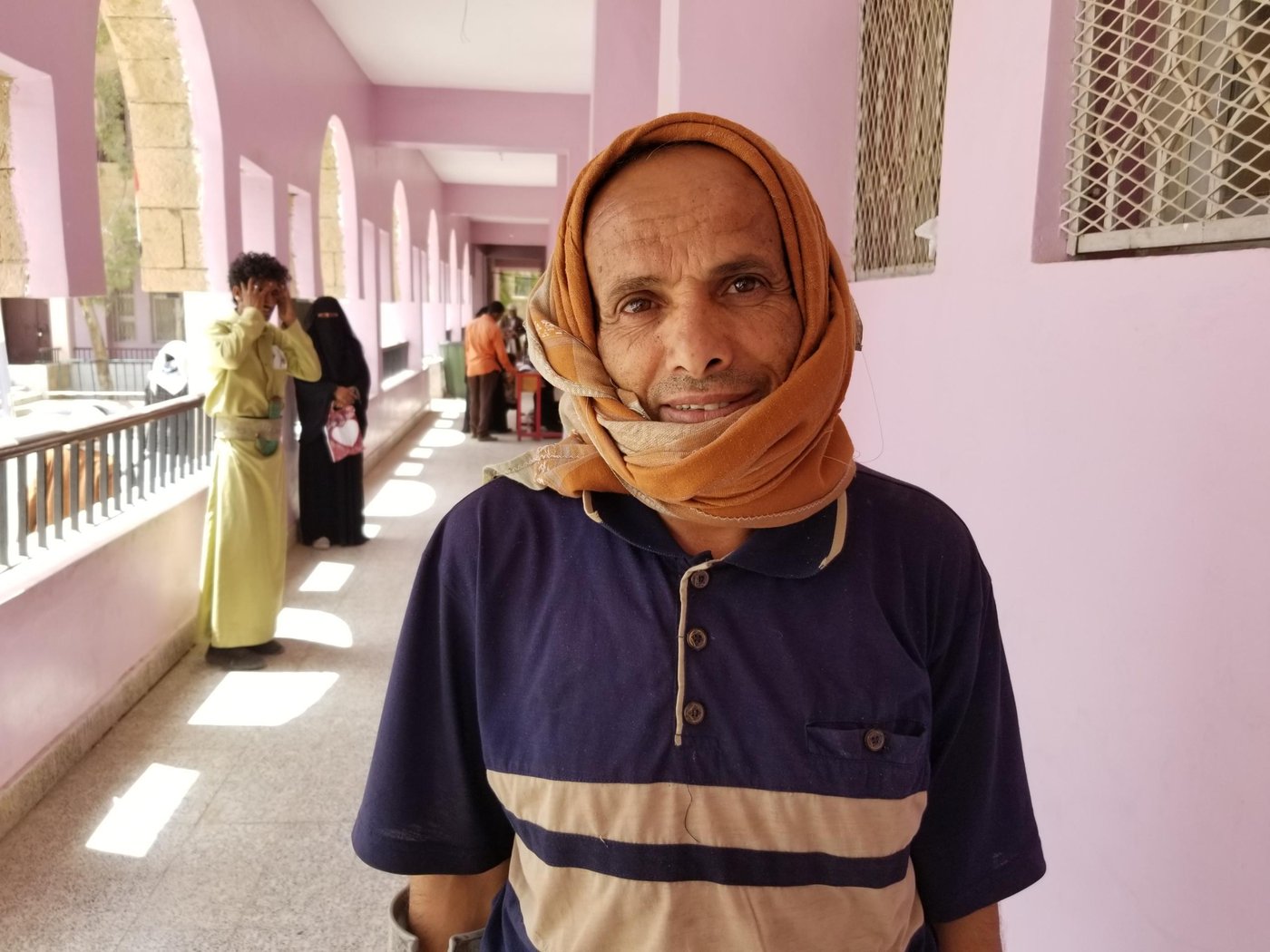 Ehsan Saeed Al-Aghbari, in his late 50s, is the breadwinner for his family of 7. He used to work as a building laborer and managed to make enough money to support his family.
Three years ago, while he was walking in the street on his way back to his house in Sana’a’s Azal district, he had a car accident. He fainted and was taken to hospital.
Once Ehsan recovered consciousness he returned home, “The driver who was responsible for the accident paid the cost of the treatment. I spent two years lying in bed, nowadays I can hardly walk,” Ehsan says.
As a result of the accident he is no longer able to work or provide his family with food and other basics. He depends on humanitarian aid and the generosity of other people to support his family.
“I’m a disabled man and cannot work. Even those who are in a good health can’t find work nowadays,” Ehsan says. “I depend on the aid that I receive from the Norwegian Refugee Council and what I get from generous people.”
When Ehsan heard about measures being introduced to combat COVID-19, he was worried that he would no longer receive food, especially after the closure of schools and Universities and other restrictions being introduced in Yemen.
“Usually the food distribution points are overcrowded. When I heard that the authorities had closed schools, I was worried that we would not be able to receive food.
“I asked my neighbors and they told me that we will continue to receive food aid but that precautionary measures to protect people from coronavirus will be taken.”
Ehsan didn’t believe his neighbours until NRC started to distribute the food vouchers in the capital Sana’a with the support of the World Food Programme.
“Coronavirus is very dangerous and we hear that advanced countries are struggling to fight it so we are scared of this disease which spreads in a dramatic way,” Ehsan adds.
“When I arrived at the distribution point to receive my food voucher, I found the place to be well organised and felt safe. There are had sanitizers at the main gate of the school and there is distance between people in the que.”
Ehsan is an elderly man. He suffers from a disability and is worried more than others as he heard that the elderly and people with pre-existing health conditions are more at risk of contracting the virus.
“We are scared of Coronavirus but we are also worried that we will lose our food aid if corona spreads in Yemen,” Ehsan says. “I hope that NRC continues to help us with food even if corona hits Yemen.”
“If corona doesn’t kill us, we will starve to death inside our houses. Millions of Yemeni’s will still rely on receiving food aid if corona hits Yemen.”
An estimated 80 per cent of the population – 24 million people – require some form of humanitarian or protection assistance, including 14.3 million who are in acute need, according to United Nations Office for the Coordination of the Humanitarian Affairs.
Ehsan did not receive proper healthcare when he had his car incident. He does not believe that the health system in Yemen is equipped to treat people with Corona.
“Precautionary measures to protect against corona are very important as the health system in Yemen has already collapsed. We hope that people take the precautionary measures into consideration.”
The delivery of health care services has been strained by fewer functional health facilities (only about 51% are functional) with the others being partially or fully damaged, according to the World Health Organization.
Photo and text: Nasser Abdulkareem/NRC