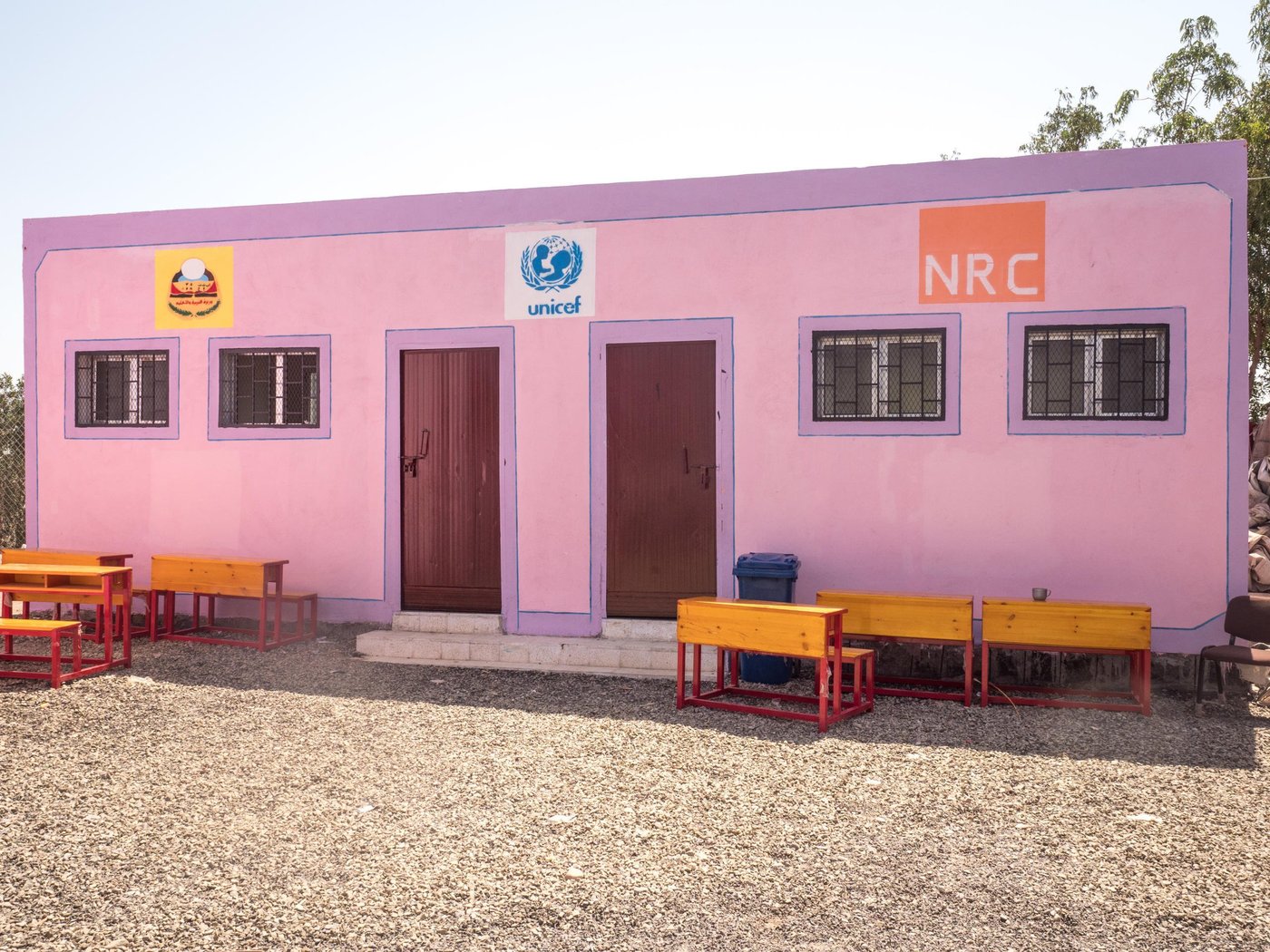Ali Abdulaleem school, located in Al-Mighefa village, in Tuban district was destroyed by airstrikes in 2015 and now unrecognisable as a school. Nonetheless, schooling has continued since the 2015 attacks, overcoming major challenges with ongoing implementation.
In the period immediately following the strikes, community members rallied to offer their own homes for use as classrooms, until tents were made available to reestablish the school site, demonstrating the commitment of communities to ensuring continuity of educational access.
In January 2019, NRC, with support form UNICEF, opened a newly-constructed school, with much celebration from children and community, who regard the school as central to their opportunities and dignity. NRC has also distributed schoolbags and provided teaching and learning materials to ensure the school can be used effectively.
NRC Education department: We prioritise seriously damaged schools in hard to reach areas, where children might otherwise be at risk fo disengaging from school entirely. NRC rehabilitates damaged schools, and constructs TLS' (Temporary learning spaces) schools that become overpopulated due to displacement. We train and support teachers in the same schools so they can teach and manage classrooms as well as possible, while providing desks and teaching materials, and distributing school bags and recreational kits to ensure students have access to the things they need to learn.
Photo: Ingrid Prestetun/NRC