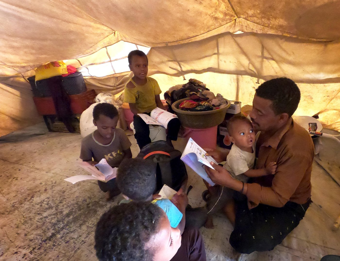 Ahmed teaches his children in their tent in Al-Malika camp in Taiz, after the closure of the schools because of Covid-19.

Photo: Khalid Al-Banna/NRC