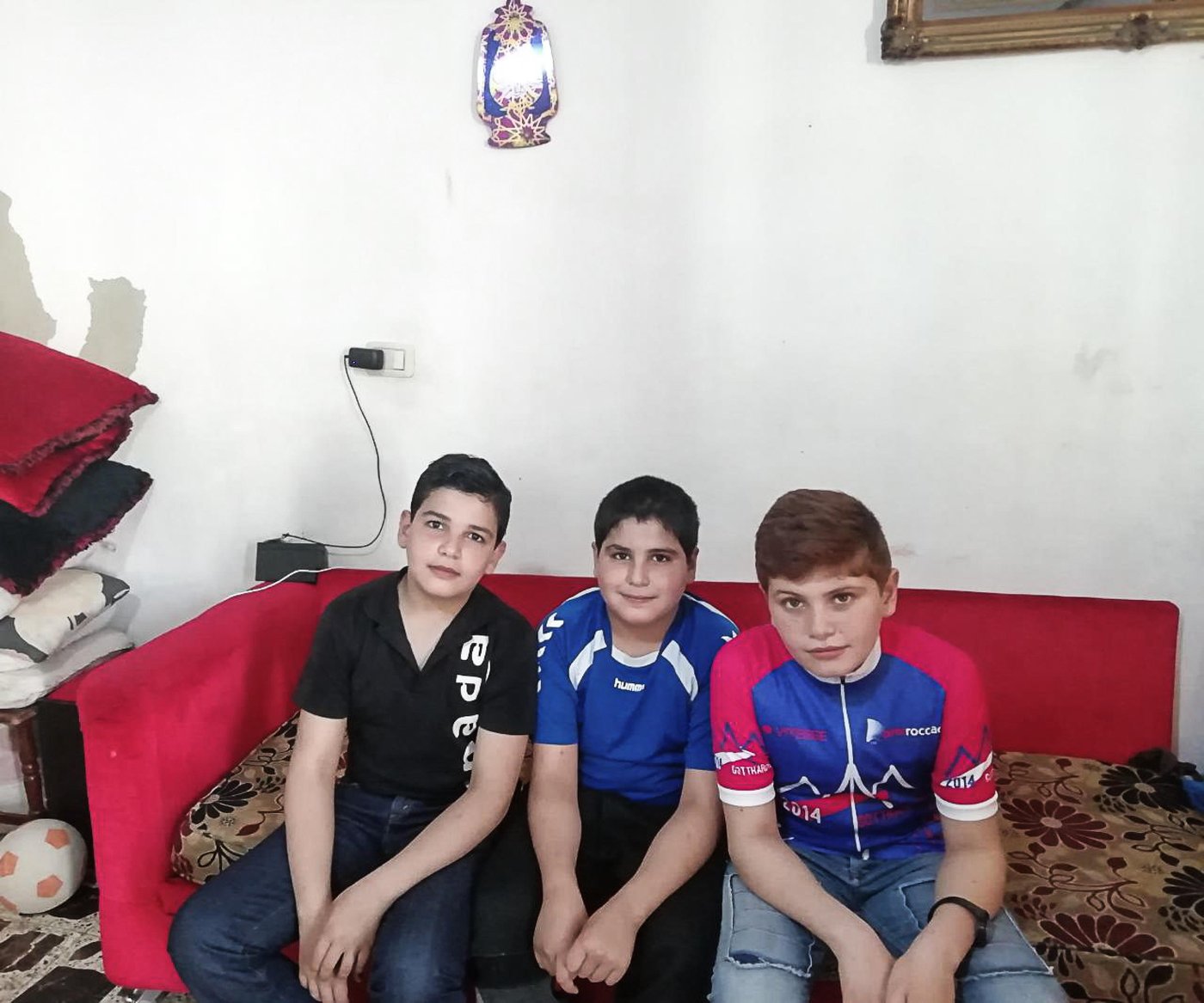 Since the outbreak of the Covid-19 the Norwegian Refugee Council (NRC) have been working around the clock to ensure that refugees and displaced children and youth can exercise their right to quality, relevant education.
Mohammad, 13, is one of these children. He is originally from Hama in Syria but fled to Lebanon together with his family six years ago. Now he lives with his parents, three sisters and three brothers in a small apartment outside Tripoli, North Lebanon.
“Although it has been six years since we arrived here, I still wish we can go back every single day. We could play football as much as we wanted in front of our home and we had a huge yard where no one bothered us,” says Mohammad. “In Lebanon we can never finish a football game, the neighbours always get annoyed and ask us to go back home. Now the situation is worse, we can’t do anything.”
Refugee children are bearing the blunt
When the activities stopped due to the Covid-19 outbreak Mohammad and his brothers were very upset. Going to the NRC learning centre, meeting their friends, and learning was part of their daily routines. “It’s not easy to stay at home, I feel down but there is nothing we can do,” says Mohammad with hesitation.
The Corona crisis has led to closed schools and disrupted the education to more than 1.5 billion learners. Refugees and displaced children and youth are bearing the blunt. Children and young people in displacement have often missed out on years of education already, due to war and conflict, and without any help, school closures due to Covid-19 will make them fall behind even further.
“To meet the needs of Mohammad and 1,200 other children enrolled at NRC learning centres in Lebanon we are now implementing remote learning modalities, including via communication platforms such as WhatsApp, combined with follow-up phone calls to provide guidance and support and to safely refer people to other specialised organisations,” says Rayan El Baf, one of NRC’s child protection technical officers in North Lebanon.
Due to the lockdown and fear of spreading the virus our colleagues are not able to visits the children and their parents. It is Mohammad’s mother, Fatima, that has sent us the photos, and it is our colleagues in Lebanon that have interviewed Mohammed and his mother.
“The remote learning has benefited my children a lot. Instead of leaving them behind during this period, NRC’s remote learning methods show us that NRC continues to care about the education of our children and appreciate their efforts to learn. It helps them connect with their inner selves, it gives them courage and strength to know their own worth,” says Fatima, Mohammad’s mother.
Nationwide lockdown
On the 15th of March, Lebanon declared a state of general mobilization in an attempt to control the spread of the coronavirus. With the nationwide lockdown, the basic survival and protection of the most vulnerable communities in Lebanon has become a critical issue. However, despite the challenges and to minimize the risk of exposure to beneficiaries and its frontline staff, NRC Lebanon continues its essential service delivery by only implementing critical lifesaving activities on-site and has tailored other programme interventions through different modalities to specifically support the national Covid-19 response.
Stay and deliver
“Although our learning centres were closed due to the Covid-19 situation, we never stopped delivering educational messages to the children,” says Rayan El Baf. “We regularly contacted them and their parents over the phone to check on their wellbeing, raise awareness on the situation and share learning materials,” she says.
Since the coronavirus lockdown, Mohammad spends most of his time at home. He either focuses on the NRC learning materials, revises the lessons, or plays with his siblings. He also sometimes helps his father at work, who sells coffee for a living.
Caring teachers
“My teacher Rouwayda always supports us to solve the exercise when we need help. She is caring and fair. Our teachers make us feel at ease and insist that we understand the lessons before leaving the classroom,” says Mohammad.
Mohammad’s mother is grateful for the support NRC gives her children. “They are always so happy when talking to the staff and are able to express themselves easily.”
“The remote teaching allows my children to revise and remember the information they received in the classes and bring some variety to the daily routine during the coronavirus lockdown. This is not only helping them to learn but also to feel more positive about the situation,” Fatima says. “The remote learning and support given over the regular calls also helps me to communicate better with my children”, she concludes.
New ways and solutions
“Though adopting remote learning modalities, we have been able to develop a positive bond between us and the parents are becoming more involved in their children’s education. Luckily, we have not faced any difficult issues with the remote learning, and we are always trying to find new ways and solutions to deal with any challenges that might arise. However, the hardest challenge is perhaps that we cannot answer the children when they ask us when they can come back to our centres to see us and their friends,” Rayan concludes.
“The learning centre was a place where I felt safe. I miss both my friends and the teachers. But most of all I would like to return to Syria,” Mohammad says.
Photo: Private