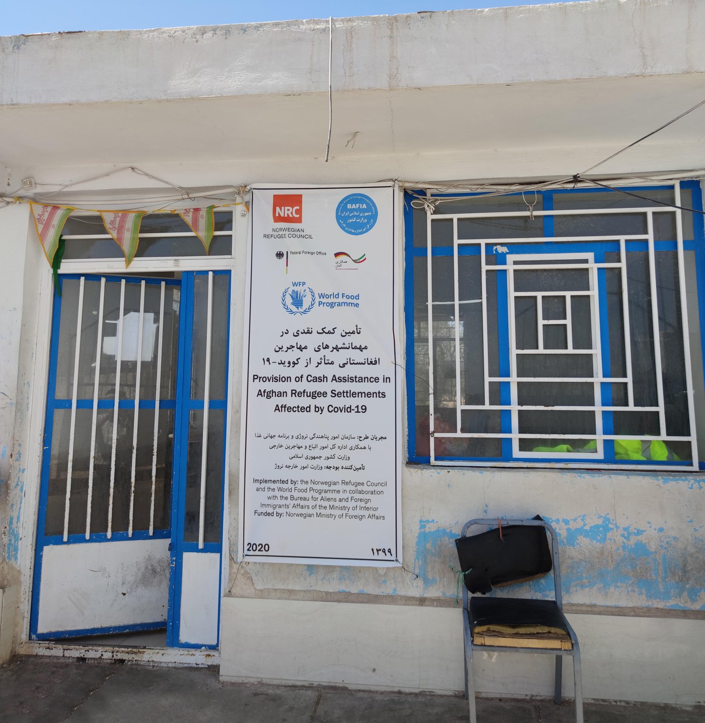 A banner at the door of the settlement's community council announces distribution of cash cards to the residents in Rafsanjan, Kerman. Photo: Javid Rostami/NRC