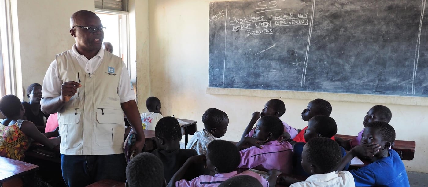 Education in emergencies expert Emile Ntampera talking to students in a school where South Sudanese refugee children learn together with Ugandan children. Imvepi refugee settlement. (Photo: NORCAP/Ida Sem Fossvik)