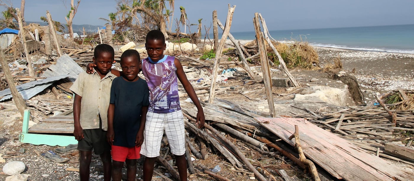 Local boys from left; George (8), Kervens (8) and Walents (13), say the hurricane destroyed their homes. They live with their families in makeshift shelters just metres away from where their old houses were. (Photo: Ingrid Prestetun/NRC)