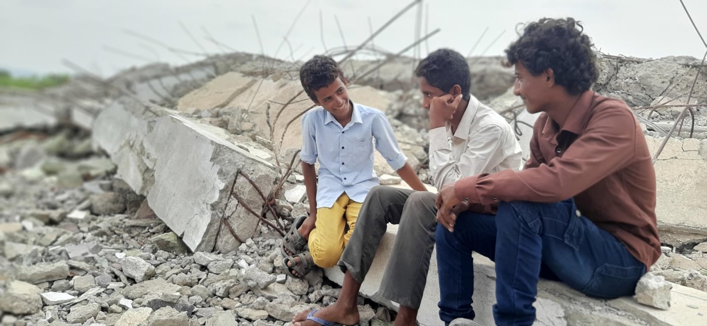 Saeed Hamood with his friends on the remains of the old school that was hit by an airstrike in Dhubab, Taiz. 

Photo : Malka Mohammed / NRC