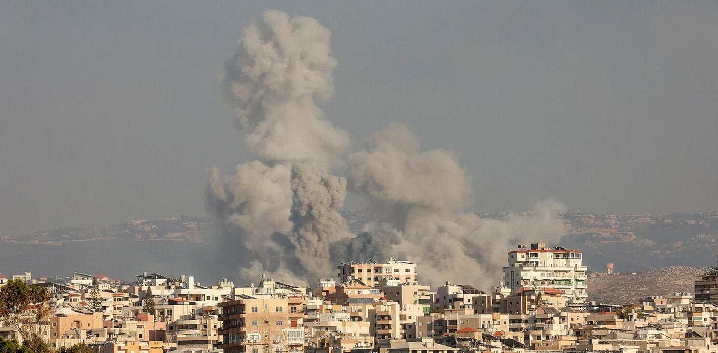 Black smoke rising behind houses in Lebanon.