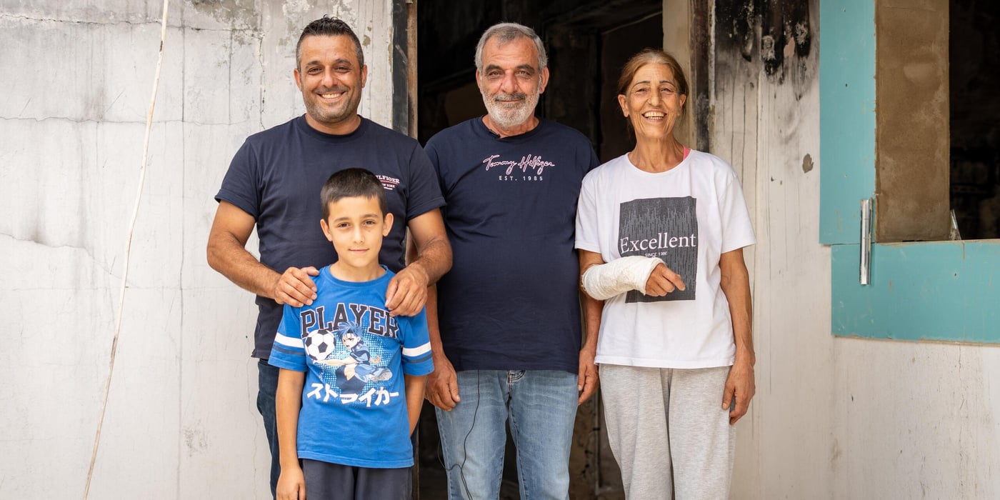 Familj som står utanför sitt hem.