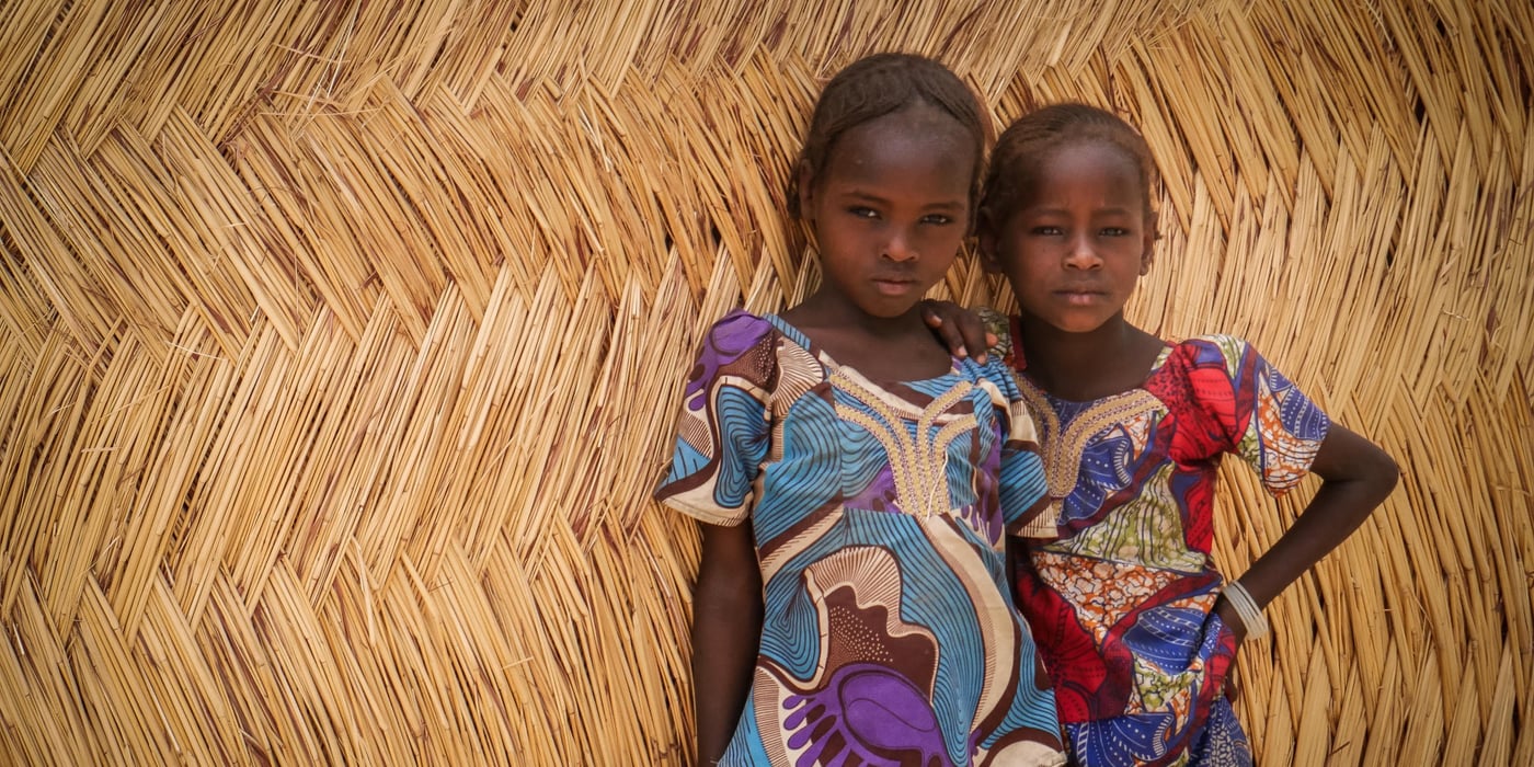 Two sisters standing in front of a transitional shelter built by NRC at Fariya camp for internally displaced persons in Maiduguri, northeast Nigeria. When this informal camp was established in 2014, there were only makeshift tents made out of tarp, straw, debris of wood and any other scrapped materials that displaced families could find. Last year, NRC started the construction of transitional shelters in the camp offering families with more sustainable housing.
Photo: Hajer Naili/NRC