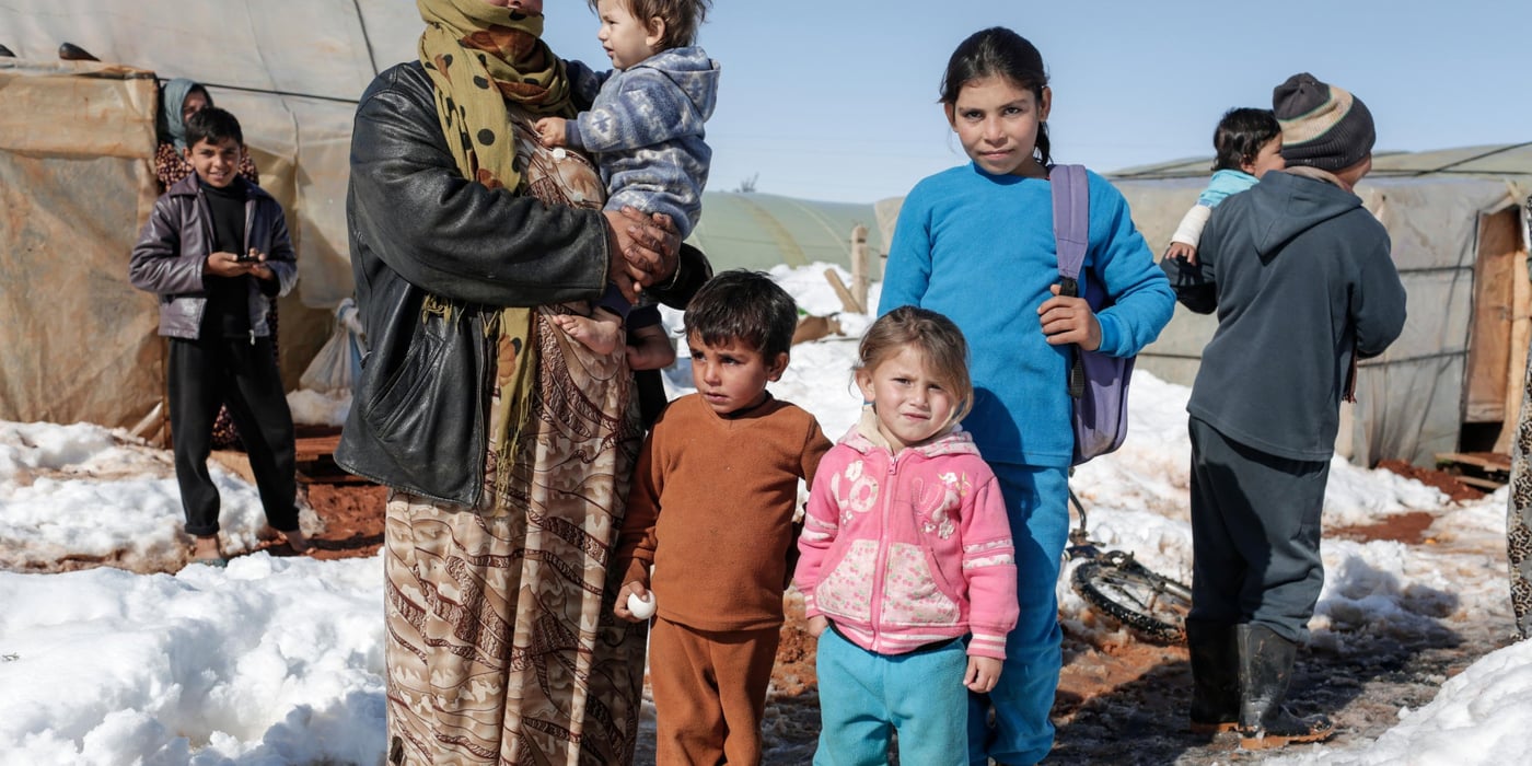 Rayya, 48, a  mother of 8 from Raqqa, stand with some of her family outside the tent in which they now live at an informal tent settlement for Syrian refugees in Sarain in the Bekaa Valley, Lebanon.

With Storm Zina raging across Lebanon, hundreds of vulnerable Syrian refugees living in tents have been badly affected by the cold. Those living in the Bekaa Valley have been particularly badly hit as temperatures fell well below zero. NRC staff distributed wood and plastic sheeting to prevent their homes from collapsing, as well as drainage kits and sand bags to prevent tents and latrines from flooding once the snow starts to melt. NRC is also delivering clean drinking water and helping empty latrines and septic tanks safely.

Photo taken on Thursday January 15.
[Sam Tarling]