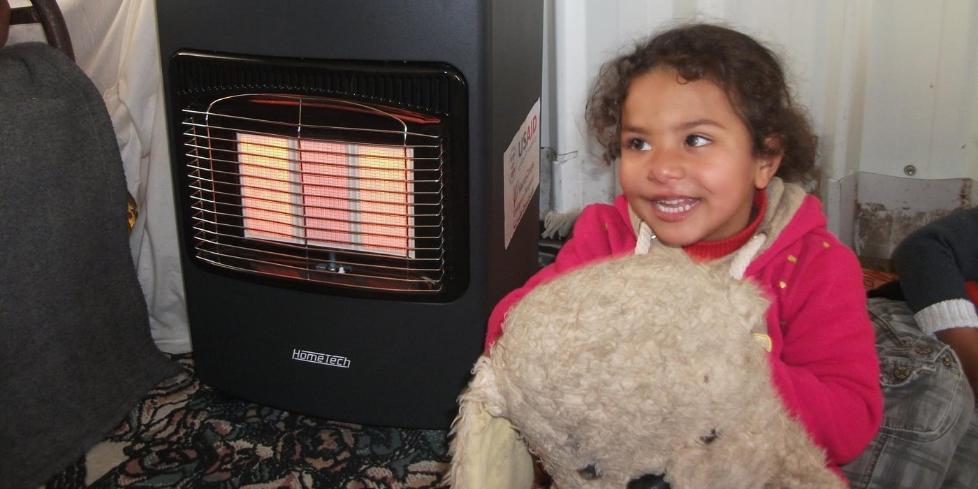 Rital Abu Raida, 5 years old, Enjoying the Gas heaters that NRC Facilitated Distribution During Winter Storm in Khuzaa, south Gaza Strip. 10.1.2015. By Mazen Naim