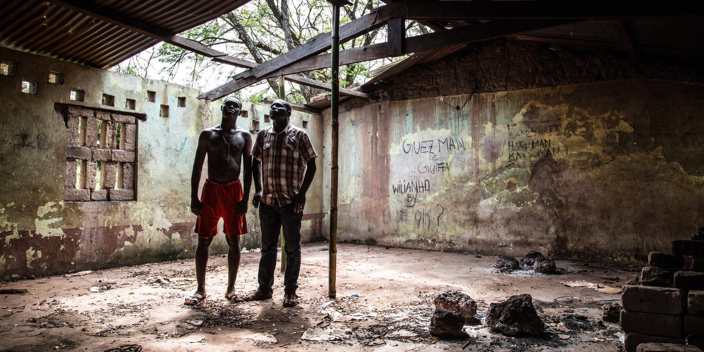 ENGLISH:
Deko - destroyed school. 
On November 7, 2014, Paulin finally returned to Dekoa for a short visit. When he arrived, he started by walking around the town with his brother, who he has just found again. The town school has been closed since November 28, 2012; Paulin observes the damage. There are no more instructors; all of them left and have not come back. The start of the school year will not take place on the date scheduled on the official calendar (November 20, 2014).

FRENCH:
Le 7 novembre 2014, Paulin est finalement retourné à Dekoa pour une brève visite. A son arrivée, il entame un tour de la commune en compagnie de son frère qu’il vient de retrouver. A l’école de la ville, fermée depuis le 28 novembre 2012, Paulin constate les dégâts. Il n’y a plus d’enseignants, tous sont partis et ne sont pas revenus. La rentrée scolaire n’aura pas lieu à la date prévue par le calendrier officiel (20 novembre 2014).

November 2014. Photo: NRC/ Vincent Tremeau