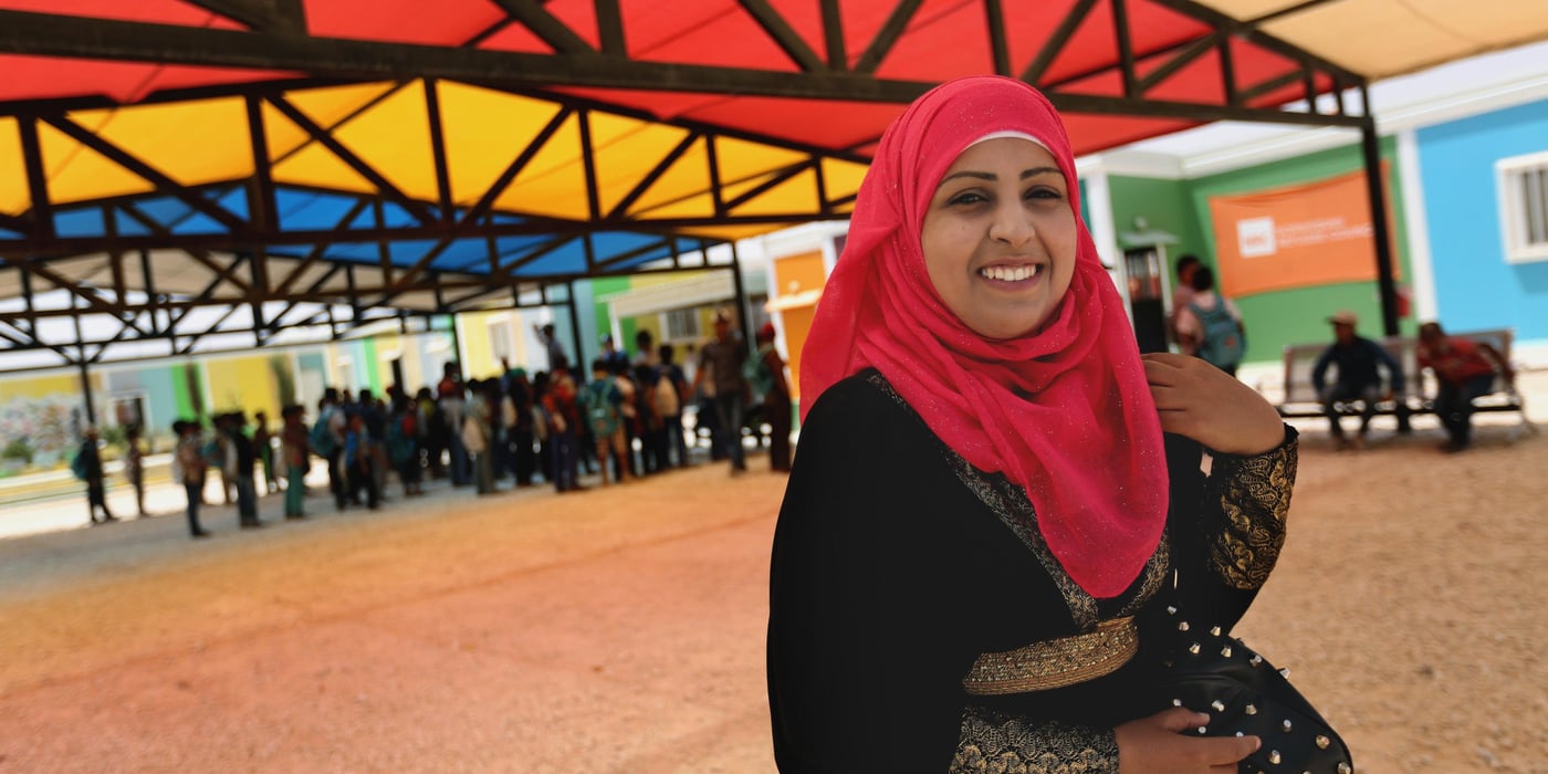 Almost every morning Alaa wakes up to the sound of children calling her name and jumping beside the small window of the white caravan she lives in to wake her up for school. Although it is a 15 minute walk to reach the centre, she looks forward to another day with her students.
The 28-year-old works as a teacher at the Norwegian Refugee Council’s (NRC) Learning Centre in Azraq refugee camp in Jordan, some 90km away from her home country, Syria.
Similar to over 54,000 Syrians who have left their homes and been registered in the camp, Alaa and her husband left Homs in 2014 in search of safety after the situation worsened in their city.
Back to teaching
Alaa was pregnant when she and her husband fled the war-torn city, and when they first arrived to the camp, her husband did not know how to help her relieve the stress and fear of arriving from a warzone.
A few months later, Alaa obtained a teaching position at the NRC centre and returned to what she loves to do. She began to feel better.
“The children helped me forget and get over the state that I was in, they fill my head with happy thoughts,” she says.
Alaa works within a recognised camp wide incentive labour scheme that provides opportunities for camp residents to contribute to their communities and earn some income to help meet their household’s basic needs.
Training for development
Having worked as a teacher back in Syria, Alaa was interested in further developing her knowledge and skills in teaching.
The education programme at NRC recently trained the Syrian community staff on modern teaching techniques and strategies for children.
The training, which was implemented by NRC staff across the three camps in Jordan – Azraq, EJC and Zaatari – aims at ensuring quality education for Syrian refugee children through coaching teachers on new teaching methods.
The training was divided into three core modules which aim at structuring knowledge, skills and professional attitudes in the fields of pedagogy, the national curriculum and professional ethics.
“The training integrates art and music in the learning and teaching processes, which makes the children happy and eager to learn more,” says Alaa.
Alaa is proud to have contributed with a set of activities to be added to the training and, with the help of Jordanian staff hired by NRC as support teachers, developed new learning games to be used in the classroom.
“I love teaching, I’ve been doing it for a while and it is my purpose in life,” says Alaa, explaining that the relationship she has with her students is not the usual “student-teacher” relationship, but something much more than that. “They treat me as their friend and their mentor, and it is more of a delight rather than a boring daily job,” she says.
Although Alaa longs to return to Syria, she looks forward to seeing her students every morning and walking with them to school, the place she calls her second home in the camp.