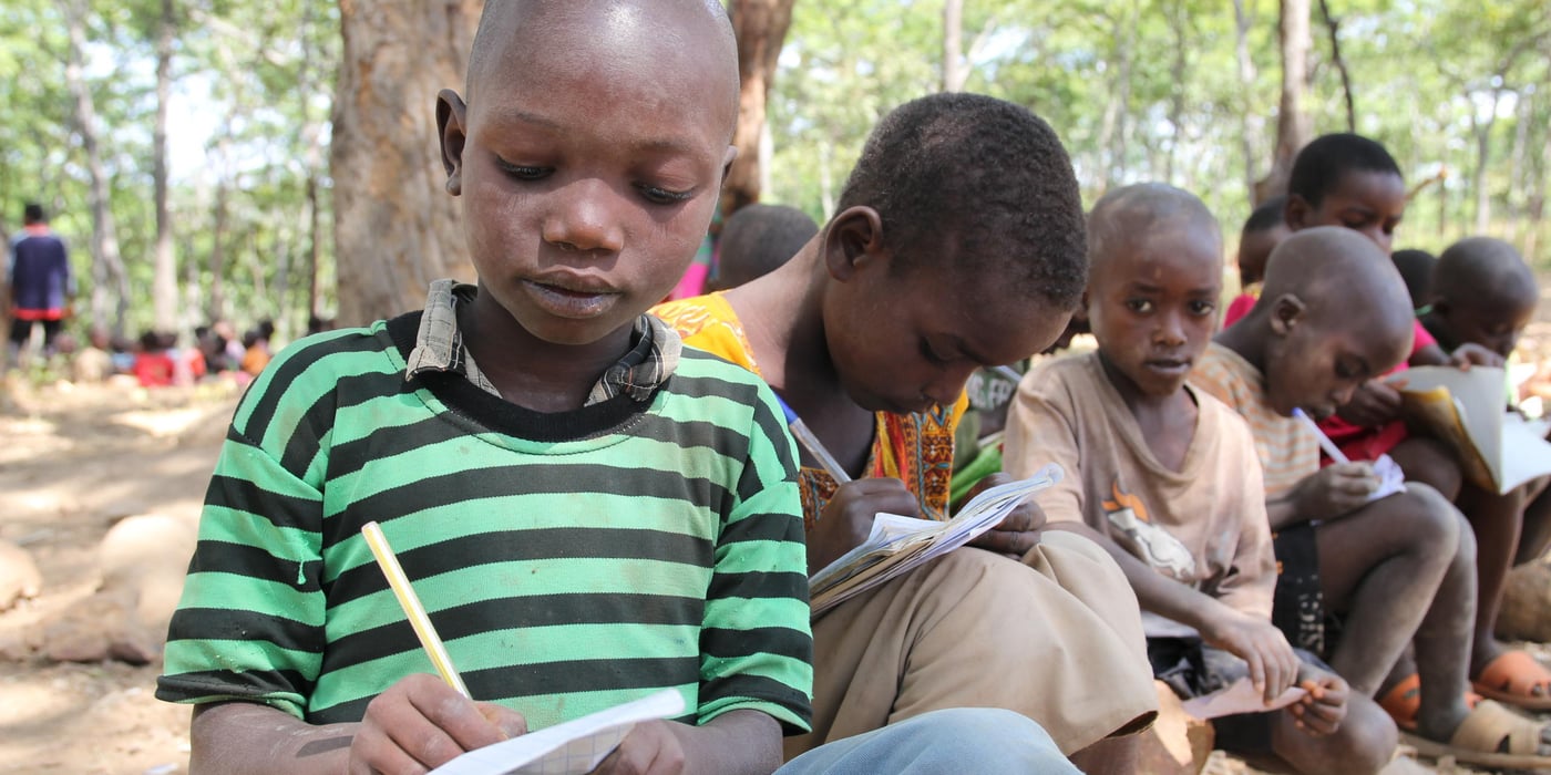 Niyongere is 10 years old. His parents are called Sebizigiye and mother Marianne. He lives in Nduta refugee camp of Tanzania. He recalls his young life back in Muremera Village in Ruyigi Province of Burundi when every night, armed men would come looking for his father Sebizigiye. His father would hide under the bed. The men would threaten to kill him when they found him.
Their home area became very insecure due to political instability. Men with dark motives prowled the streets at night. Even walking to school in the morning became very dangerous. One day, one of his classmates was killed on his way to school. He heard about it during an announcement by his teacher Mrs. Nishimiye. He had also lost contact with his best friend Sengiyuva before leaving Burundi, and has never heard from him again.
He likes Mathematics. “Maths helps me to learn how to count numbers. I am fascinated by numbers. I can count from one to ten in Swahili, English and Kirundi,” he says. While in Nduta refugee camp, Niyongere’s best friend is called Mugisha. He dreams of becoming a teacher when he grows up. He thinks teaching is a very noble and fulfilling work.
However, he lacks learning tools like pencils and books. To help him during class, he borrows from the teacher or from other students. While at home, Niyongere has improvised a new method of doing homework. He has kept aside stones that he uses to write on the soil outside their tent.
During his free time he goes to fetch water from the river. He also spends time looking for firewood. Together with Mugisha, they like to play football. They also play cards, which involves picking cards from a pile and displaying in turns. The person with the highest score wins. He says that he wins most of the time. In addition, Niyongere, whose name means ‘give me more’, spends a lot of time chatting with his father. When he was born, his parents offered a prayer to God to give them more children. His says that his father encourages him to love education. He helps his mother to cook.
Quotes from Niyongere:
“I miss the school where I was studying. In Burundi, I had school bag, shoes, clothes and pens.”
“I miss the school where I was studying in Burundi. I had enough materials: shoes and clothes, pens and a school bag, rubber. I also had friends who loved me so much.”
“But here I do not have materials. I do not have exercise books. When I want to write, I borrow papers from friends or the teacher. He gives me a paper and pen and I write. Also we sit on stones.”
“I am happy because I am in the camp. I get peace. Even though we do not have built schools, they will help us.”
“I want to study with all my efforts so that I finish studies and become a teacher, as I want to be in my life.”
“I like school so much. I also like to learn.”
“You see, in Burundi I had exercise books, pen, school uniform, school bag, shoes. But here, I do not have them.”
“You know, I left the school in Burundi when we came here.”
“We decided to flee Burundi because there was conflict. They were hunting for us, they wanted to harm us. That is why we decided to come here. We left because they wanted to kill us.”
“I feel better because I left a conflict area to come to a non-conflict area, to live well.”
“You know, in Burundi I had friends. One of those friends was Tuyisenge Moses. Another one was called Niyibitanga Sekis. Another one was Nakayibona Methode.”
“You know, in Burundi we could farm tomatoes, cassava or farming maize, or farming vegetable or peas, we also kept goats. I had friends but I do not see them here.”
“I miss the school where I was learning and friends and home and relatives.”
“Because we are studying in the open sometimes people pass by talking and we are distracted. We cannot follow the lesson well.”
“When another teacher is teaching a nearby classroom, we look at him and fail to follow our teacher.”
“I like to be a teacher so that I teach other children like how I am being taught”
“At home, my parents, siblings and myself we were afraid that they would harm us. I used to hear that others had the same problems.”
“But when I heard that we wanted to come here, I became happy.”
“Thank you very much for telling my story.”
“I miss my exercise books, pen and school bag, school uniform and shoes.”
Photo: NRC/Ingrid Prestetun