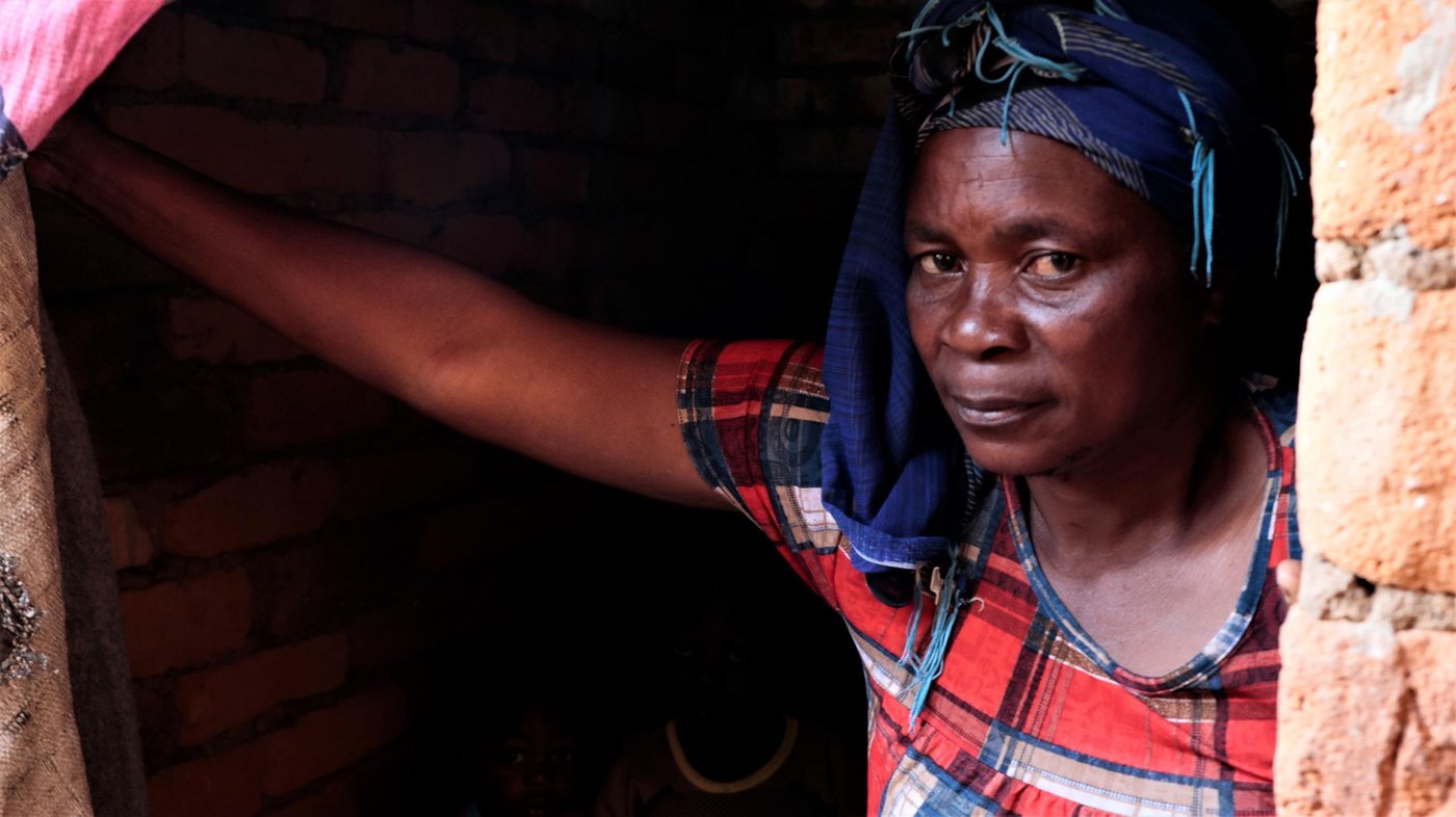 Yvonne is 45 years old and the mother of ten children. The old woman has been living in Mulima village since she fled bloody violence in her village of origin Mikenge in the highlands of Fizi territory in the southeast of the Democratic Republic of the Congo. 

In Mulima village, Yvonne shares a small room with the two little orphan boys whose parents were slaughtered during attacks. Before she settled inside, the room was uninhabited and uncompleted from constructing. It has neither door nor windows, but the old woman has no other choice rather than endure elements and cold. Amid cold and elements, Yvonne has struggled to find a dirty small piece of curtain that she uses to serve as a door, but this is not enough to protect herself from either thieves or bandits in Mulima village.  

“We are hungry and almost naked; militiamen had looted everything we had, leaving us uprooted in inhumane living conditions,” she says. 

To seek safety, the old woman walked about 60 kilometres a distance from her home village—going up and down hills and valleys of Fizi. Sometimes, she had to sleep in the forest with nothing to eat so that she escapes the armed men who were looting and licking civilians on the roads. To reach Mulima village where she has settled since she fled, Yvonne fled village to village, day and night in appalling conditions— with no food and water.

“When the clashes broke out, I was harvesting maize in my field near the village. Suddenly, I saw houses burning to the ground and people running in all the directions. I knew then the situation was bad and I quickly scrambled to hide in the bush,” recounts Yvonne in an emotional tone of voice. “Everywhere I hid; armed men would come to attack and forced us to flee,” she says. 

“Since we have arrived here [Mulima], we do not have access to food and our children had stopped going to school. We lack everything, mattresses, blankets; clothes; shoes and pans. We are suffering,” explains Yvonne. To find food, many displaced like Yvonne have developed some poor coping mechanism that however exposes them to additional protection issues like rape or killing as they have to go far away a distance to seek firewood in the bushes. “Every day we get up early morning to cut firewood in the bushes that we sell to the residents so that we buy some food to refresh the mouth”, “For a lucky day, we earn 2,000 Congolese francs, the equivalent of USD 1.2”, declares Yvonne. 

November 2019
Photo: Ephrem Chiruza/NRC