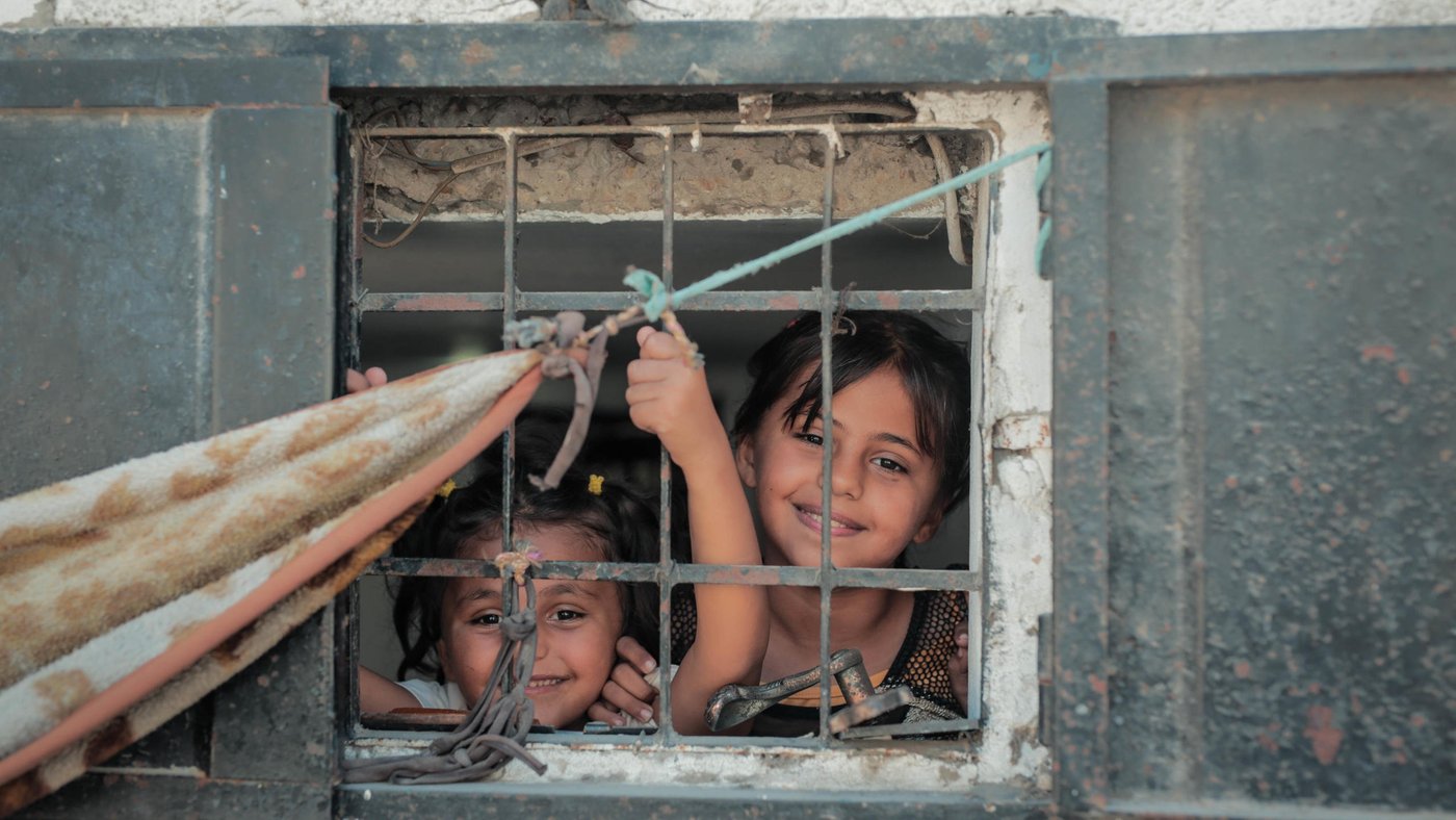 Remas Al-Zaharneh, 7, and her sister Layali, 11, looking from their apartment window.
Photo taken on 21 August 2019, Jabalia, northern Gaza.
Photo: Ahmed Mashharawi/NRC