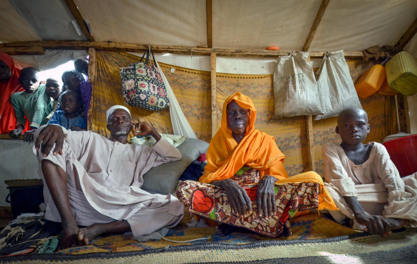 Ya Hawa (middle) sits with her husband and son in the shade of her tent, shielded from the midday sun. She has been living in Monguno village in northeast Nigeria since Boko Haram attacked her village in 2015.
She fled her home town with her six children. “They set all the houses ablaze. They killed members of my family,” she remembers.
“I’ve been living in this camp for two years,” she says. “I want to go back home as soon as I can but only when Boko Haram are gone. Then I’ll feel safe. Here in the camp there is an informal teaching centre where my children can go to school.”
Today, she shares her tent with her husband and children. It’s small in comparison to what they had before the war. But it feels safe.
She recalls the life she had before the conflict broke out; “I come from a big farming family. We reared animals. Our village had 3,000 cows. But Boko Haram stole them all. What have we now?”
Eight years of armed conflict has left some 1.8 million people in Nigeria’s northeast. The region is suffering a triple crisis – hunger, cholera and conflict. While the country has managed to avert famine for now, 5.2 million people still do not have enough to eat. Close to half a million children are suffering from severe acute malnutrition.
The Norwegian Refugee Council is working in Monguno town where Ya Hawa now lives. We are providing shelter, water and sanitation to families in need.
In a new report launched by NRC called ‘Too Scared to Return ’, we found that 86 per cent of displaced people are not ready to go home. Insecurity is the main reason people want to stay put.
Date: 4 October 2017
Credit: Norwegian Refugee Council / Michelle Delaney