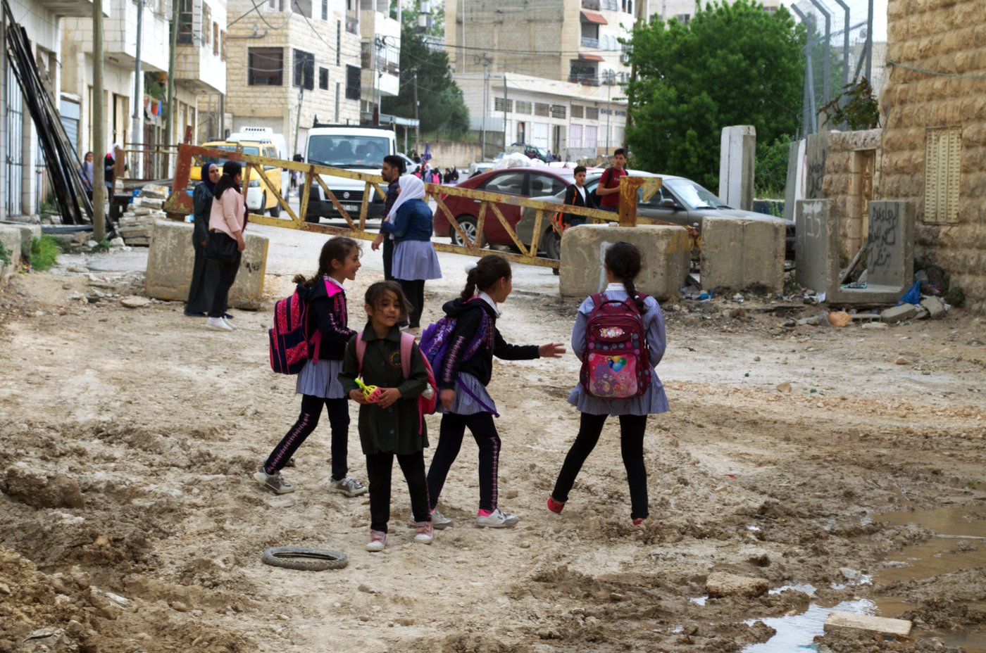 Children heading home from school pass the yellow steel gate at Qafisheh checkpoint in Hebron's Tel Rumeida neighborhood on 2 May 2019. 
Photo: Ivan Karakashian/NRC