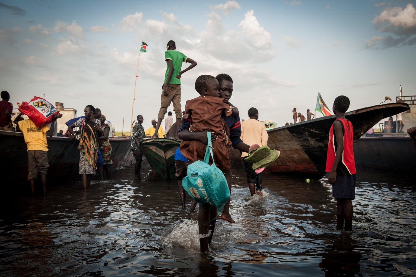 People displaced from Bor further up the river Nile are arriving to Minkamman refugee site by boat. Jan Egeland and Idar Kreutzer visited IDPs in Minkamman site, where NRC is distributing NFIs such as shelter materials. NRC is also involved with education in Minkamman. (Photo: NRC/Christian Jepsen) February 2014