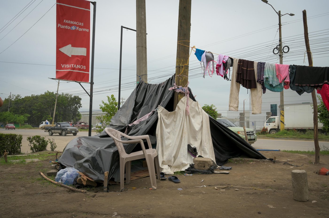 Along the highways leading into the city of San Pedro Sula, hundreds of families displaced by the devastating floods caused by hurricanes Eta and Iota, have sat up improvised camps with sticks and plastic sheets. Others sleep under bridges inside the city – some in tents while others have tied together pieces of plastic and cardboard to secure a minimum of privacy and protection.
The new roadside camp continues kilometer after kilometer as you drive out of San Pedro Sula in the direction of one of the worst hit areas around the city of La Lima: On one side of the road the lower-lying neighborhoods are a mess of mud and debris, while the other, higher situated side have now been converted to an uncomfortable campsite for families whose homes have been ruined by a tsunami of mud.
A few black or blue plastic sheets are coving the few belongings that the families managed to take with them or have sourced after their escape. Outside, intricate webs of strings are holding the families’ clothes that never seem to get dry. In a gas station on the road between San Pedro Sula and La Lima, a dozen families have sat up camp and living from day to day, while their children live dangerously between the cars that are all around them on the highway and in the gas station. Almost no one are wearing any masks to protect themselves against the risks of Covid-19. Luxuries such as mattresses are a thing of the past and now replaced with pieces of cardboard. The only assistance that the families at the gas station have received are a daily meal supplied by church organisations.
The people at the gas station are grateful for the assistance they receive from churches and passersby. "The people are helping the people," is a mantra often repeated. But what they really hope for is a durable solution coming from the national authorities.
The number of people in this situation is unknown.
Photo: NRC/Christian Jepsen