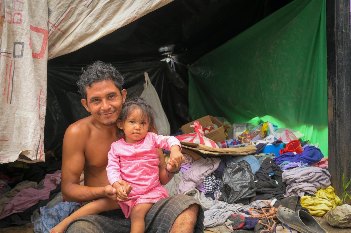 Marlon and his family lost all their possessions in the floods caused by hurricanes Eta and Iota that made landfall in Honduras in November 2020. Together with his wife and one-year-old daughter, Marlon made a quick escape from their neighborhood in Jerusalem nearby the large city of San Pedro Sula. 

They are squatting on the grounds of a gas station in La Lima municipality alongside many other families in the same situation. A few plastic sheets are coving the clothes that have been donated by people passing by the gas station. Luxuries such as mattresses are a thing of the past and now replaced with pieces of cardboard, but church organisations are providing a daily meal to the displaced families at the gas station. 

"We didn’t manage to get anything out of our house, when we received the warning about the incoming flood. I tried to get a few items with us, but it was too late, and the rain was very strong,” Marlon told.

“The first night, we slept outside a building without having any food. We managed to bring some clothes for my daughter, but my wife and myself only had what we were wearing. That first night, the rain poured down on us and we have been living on the streets since then.”

With the help of other people, we made this plastic roof which has helped us a bit. Today, a woman brought us fruits for my daughter. Before we moved into this shelter, we got soaking wet from the rain, which especially affected my young daughter and my wife, who has health problems and is pregnant at the same time.”

My wife has suffered from epilepsy since she was seven years old. Yesterday she had a seizure because she took the wrong medicine, so now she is dizzy and cannot get up by herself.

Milagros [miracles] is my one-year old daughter’s name. We choose this name because it is what she is: we did not know that my wife was pregnant, she had a heart attack and was in a coma for three days, then we found out that she was 8 weeks pregnant and the doctors said my wife was not going to wake up. We prayed and the girl is here safe and sound".

Photo: NRC/Christian Jepsen