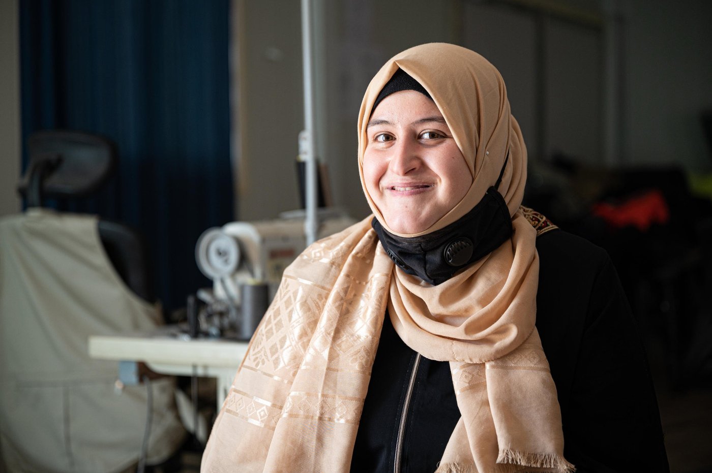 DO NOT USE (embargoed by head office)
Photo: Daniel Wheeler/NRC

Description: Ala (22) poses for a portrait. 

Factual information

First name: Ala
Age: 22
Current location: Za’atari Refugee Camp, Jordan
From: Daraa, Syria. Fled to Jordan in 2012
Occupation: Seamstress at NRC’s youth programme.
NRC beneficiary: Yes, Ala received seamstress training as part of NRC’s youth training programme and now works as a seamstress as part of the programme.

Interview

Ala’s words

“I fled Syria in 2012 because of the heavy fighting. I left on foot at 10pm and arrived at the Jordanian border at 6am the next morning. We travelled at night because we were terrified of being attached on the way. There was around 100 of us and many people were injured. 

When we arrived at the border and were met by the army (Jordanian Army) I felt like a drowning person that had been saved. I felt on edge the entire journey and now I had soldiers telling me ‘You are safe now’, it was all so overwhelming. 

I live with my five sisters and five brothers. I am the eldest, so I feel responsible for them, and I looked after them during coronavirus. 

I found out about NRC’s youth programme after doing a four-month sewing scholarship with a different organisation. I became very passionate about sewing so I wanted to continue my training and the programme at NRC seemed perfect. When I started on the programme, I realised that I still had so much to learn, and it was very intensive but rewarding. 

The programme is delivered in three phases, with the first stages being training and the third phase being an employment opportunity. 

I live on the other side of the camp and walk an hour each day to get to the centre. It’s a long walk in the desert heat but it’s so worth it. 

An average day for me is waking up at 6am and after getting ready, I walk to the centre and we started work at 8:30am. At 12:30am we have a lunch break and then we work until 3pm. After I walk back home, I usually have a nap because the work is tiring but very rewarding. 

When asked what the programme means to her, she replies with: “This opportunity that NRC has given me has provided me with financial independence and an opportunity for success in my life. My father is so proud of me and that is very important to me.”

When asked what she wants to do in the future, she says: “In the future, I want to open my own sewing centre for women which has integrity and quality – just like NRC.”