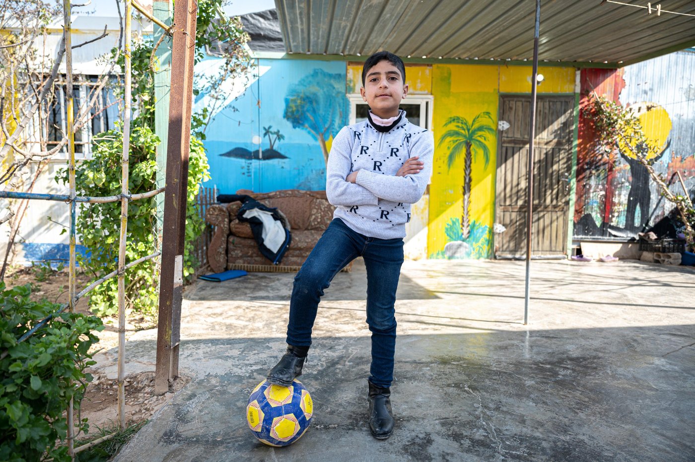 Ten-year-old Osama has not known any other life than being a refugee. He was born two months after his family fled to Za’atari camp in Jordan in 2012.
“When the situation in Syria deteriorated I had no choice than to leave to get my family to safety,” says Osama’s father, Mohammad, 49. “I through we would return after two months but did I never imagined 10 years would pass by and we would still be refugees.”
Osama only knows Syria through the story of his parents. In fact, he has never even met any of his relatives living in Syria. “I show him the videos they send on WhatsApp to me and I tell him who everyone is,” says Mohammed.
“My dad tells me about his childhood in Syria, what our house was like and about my grandfather and that he was a very good man. He always tried to help people and I wish I had met him before he died,” says Osama. “I like to look at pictures of him and see the farm where my dad grew up.”
“My son, Osama, can’t even dream of the future because he has lived in limbo his entire life. I encourage him to study and do sports and take any training opportunity he can get but I really don’t know what type of future he will face if we remain refugees,” Mohammad concludes.
Photo: Daniel Wheeler/NRC