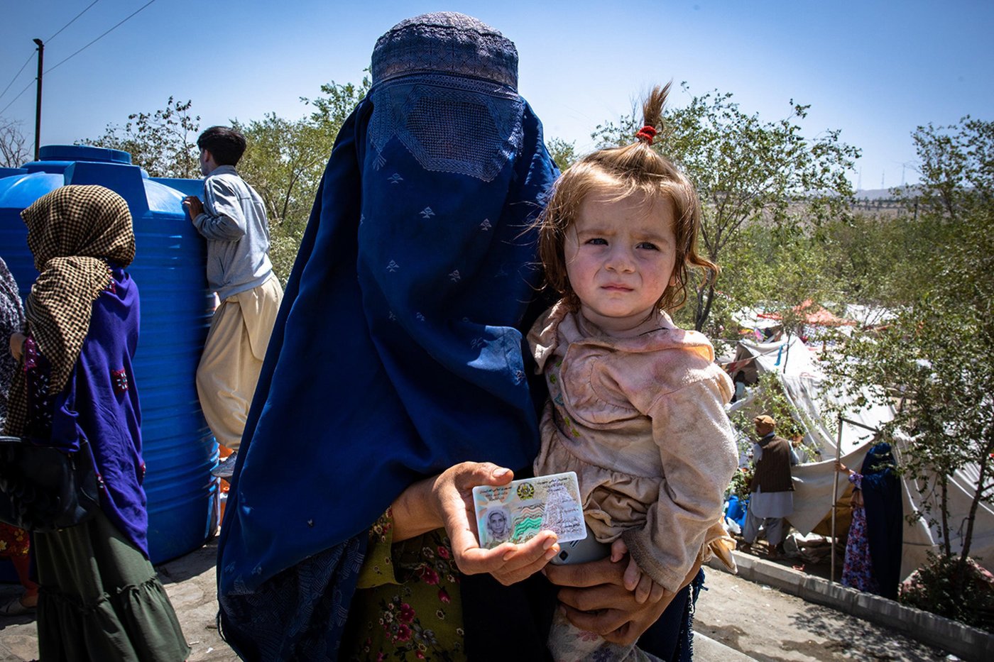 A woman with her 10 month old daughter on her arm.