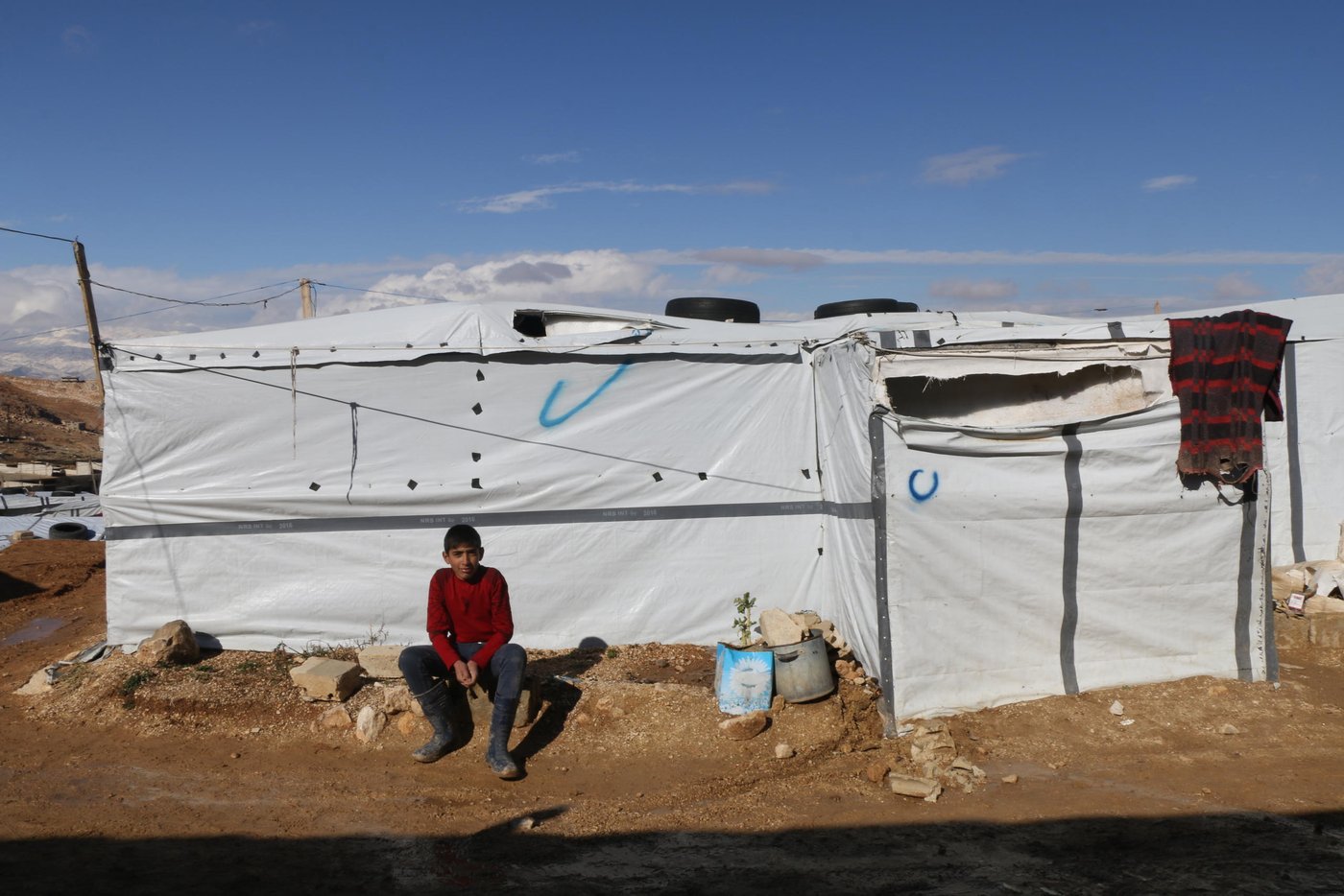 The family are struggling to repair the damage, and are having to rely on the help of their children in the hope of moving back in.

“My husband is trying to repair our shelter with the help of our 10 and 8-year-old sons, Mahmoud and Adnan. They are removing nails, replacing the timber and covering the roof so the tent doesn’t flood anymore. They work as if they were adults,” says Intisar, 36, a Syrian refugee who lives in Arsal.

As harsh weather conditions sweep across Lebanon, thousands of Syrian refugees have been left vulnerable in the hill town of Arsal. The Lebanese government opposes the creation of formal refugee camps, so many refugee families have resorted to living in informal tented settlements.

Photo: Racha El Daoi/NRC