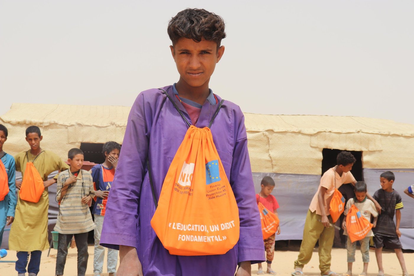 Portrait of a young student. He is carrying an orange tote-bag.