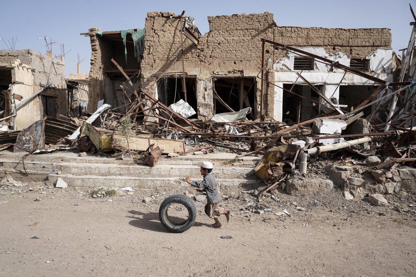 A young boy runs with his tyre past buildings damaged by airstrikes in Saada's Old Town in Yemen. Up until August 2015, this area was home to Saada's oldest market with thousands of people selling vegetables, spices and fabrics in stores and street stalls. (Photo: Giles Clarke/UNOCHA)