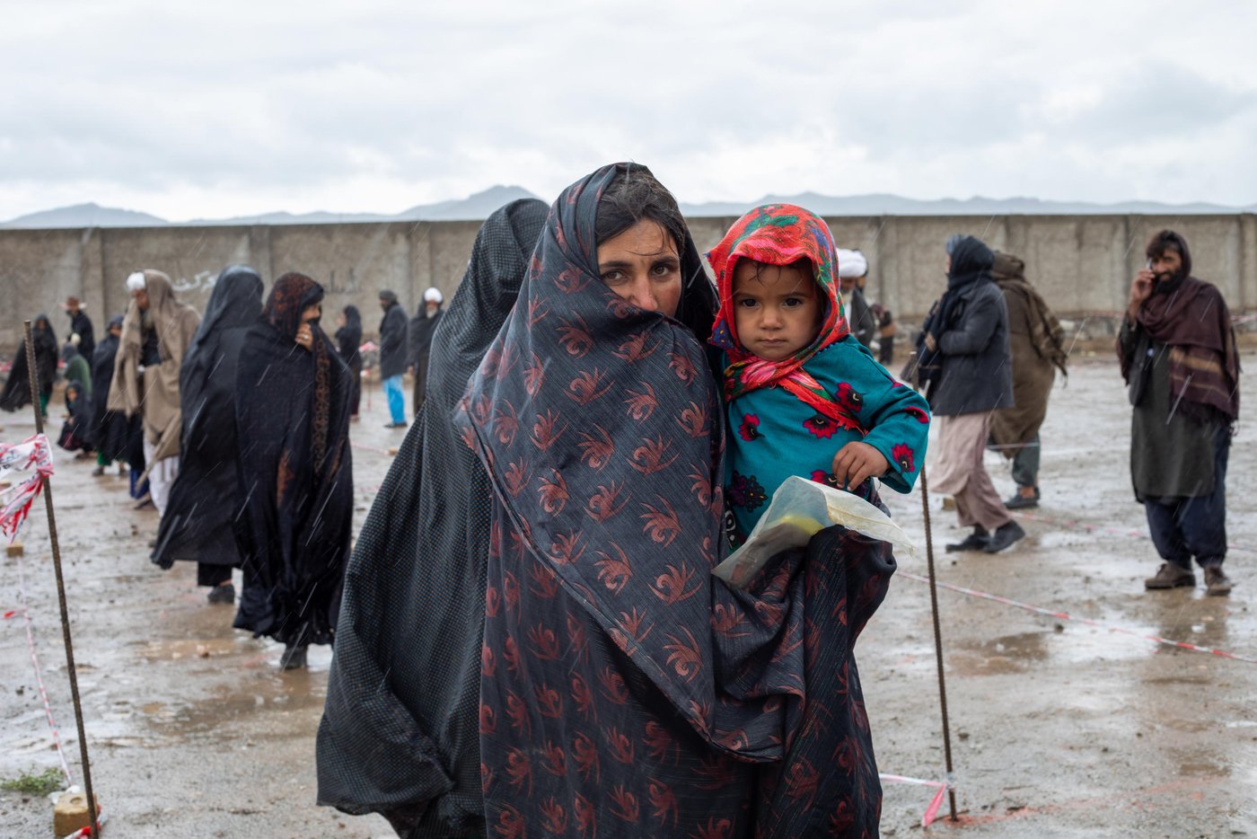 “Handwashing with soap is a good way of removing dirt and deactivating any virus or disease, but what should we do while we are bare-footed?” Says Lailuma while carries her daughter standing at NRC distribution point.
“It has been two years that we have been abandoned here. We are getting poorer everyday. Now that this disease has spread we can’t even afford a soap to buy. This and any kind of assistance will be very useful,” says Lailuma.
NRC WASH team is undertaking a ten-day hygiene kits distribution in Herat reaching to total of 7,000 families. But the families are less concern about COVID-19 virus than about the lack of livelihood opportunities and lack of food.
“It is the season to work on the opium poppy fields and many men from this settlement, including my husband has gone to work in Helmand,” she says without any hesitations. “Men didn’t work the whole winter and it’s that time of the year that they can earn. They can’t get a job here in the city and if it’s not the poopy field we can’t make a living any other way.”
Photo: Enayatullah Azad / NRC