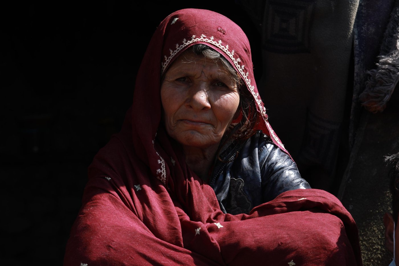 Shayista Gul, 60, and her son Esmatullah, 17, sitting in front of their makeshift shelter on the outskirts of Kabul city. The family have been living in this IDP settlement for 13 years now since the time they have been returned from Pakistan where they lived as a refugee. The family has no source of income since Esmat lost his father in an explosion in east Nangarhar province who was the primary income generator of the family. Now, 15 people, including Shayista’s daughter and her children, who also lost her husband in the same explosion are living in a two-room makeshift home.
Quotes from Shayista: “Since the outbreak of this diseases the price of food items are raised to double folded. I went to a nearby shop this morning to buy soap and detergents, but I could not buy it as the price was increased. Now, I’m washing my clothes only with water without using any detergents.” “we are staying on government owned land and there is no borewell or water tap close to the settlement. It takes at least five minutes to fetch water from a well inside another colony.”
“We usually rely on community donation here and I heard that price of a bag of flour had increased by 1200 (approx. $16) yesterday and in this case, families might not have sufficient food themselves to help us anymore. We noticed that everyone who could afford was rationing foods and we are just left like that. If things get worse in the coming days or weeks and food and vegetables falls short and shops remain close, we will be left hungry and might lose our loved ones.” “even if the government ask us to stay at our homes, we can’t. we have to collect scrap to feed our children. If not, we die out of hunger and not having food. If Coronavirus do not kill us, hunger will, definitely.”
Photo: Enayatullah Azad / NRC