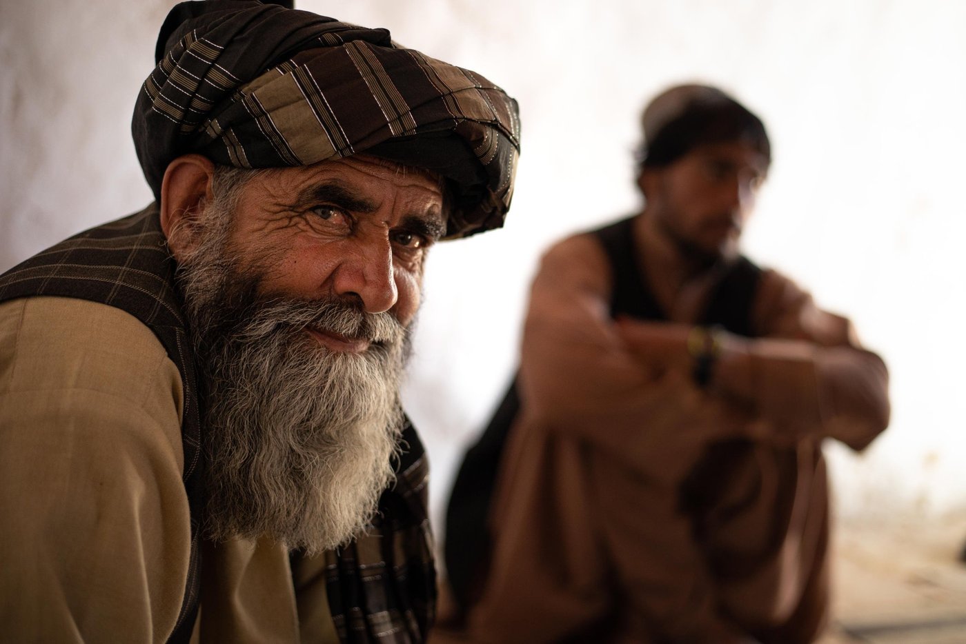 Abdul Raziq, 60, attended an NRC hygiene promotion workshop in a settlement outside Kandahar city. With ECHO support, NRC is implementing WASH, ICLA and protection interventions in Kandahar, Zabul and Uruzghan provinces in southern Afghanistan. Given the ongoing Covid-19 pandemic, NRC’s WASH and protection interventions, include specific efforts to prevent and respond to Covid-19 among conflict-affected populations.
“We lost at least five people during the pandemic in this site. Many got infected but a few lost their lives. We have to be careful now and need to know more on how to protect ourselves and people around us. We have learnt a lot and will pass the messages to our family and friends when we get of this workshop. We have been chosen to attend this workshop to pass the messages to them.”
“During the COVID-19 crisis, we didn’t go to public hospitals. It was crowded and were paying less attention to the COVID-19 cases we have heard. There were rumors that patients were sleeping on the yard and corridors as there wasn’t enough bed for everyone. Everyone was feeling powerless in this community and we stayed at home fearing the disease.”
“My two young sons and I worked as daily laborers before COVID-19 and we all lost our jobs when the lockdown restrictions were in place. We couldn’t find a job for almost three months then the markets opened and businesses restarted. Now it’s OK and at least one of us can go and get a daily wage job.”
“We have a hard winter ahead. Previously, we were working during the summer to save some for the winter months, but this year is totally different. We work and eat that in the same day and there is no savings for the harsh winter ahead. We hope government and aid agencies support the displaced families in the camps.”
Photo: Enayatullah Azad / NRC