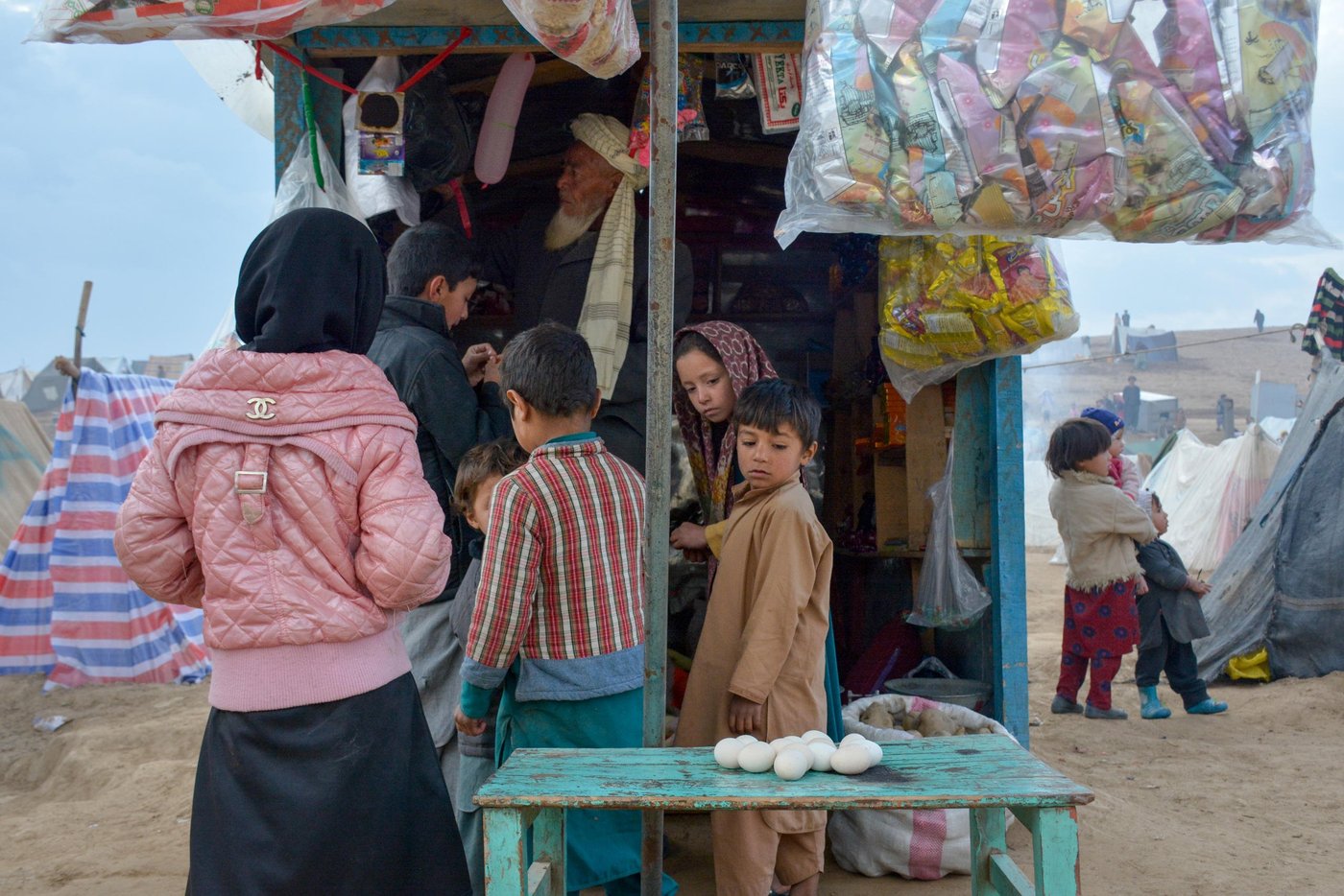 Displaced children staring at the eggs in fort of a small stall in Feristan IDP settlement. People have lost their saving and can’t afford buying meat and food for their children. They are usually taking food two times a day and that’s only boiled water with sugar and wheat bread. Photo: NRC/Enayatullah Azad