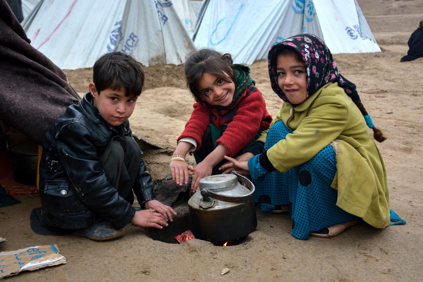 From right to left: Naseema, 9, Gul Ghotay's daughter and her friends, Dunya Gul and Mohammad Arif, warming their fingers in a cold day in Feristan IDP settlement in Qala-i-naw, Badghis. PHoto: NRC/Enayatullah Azad