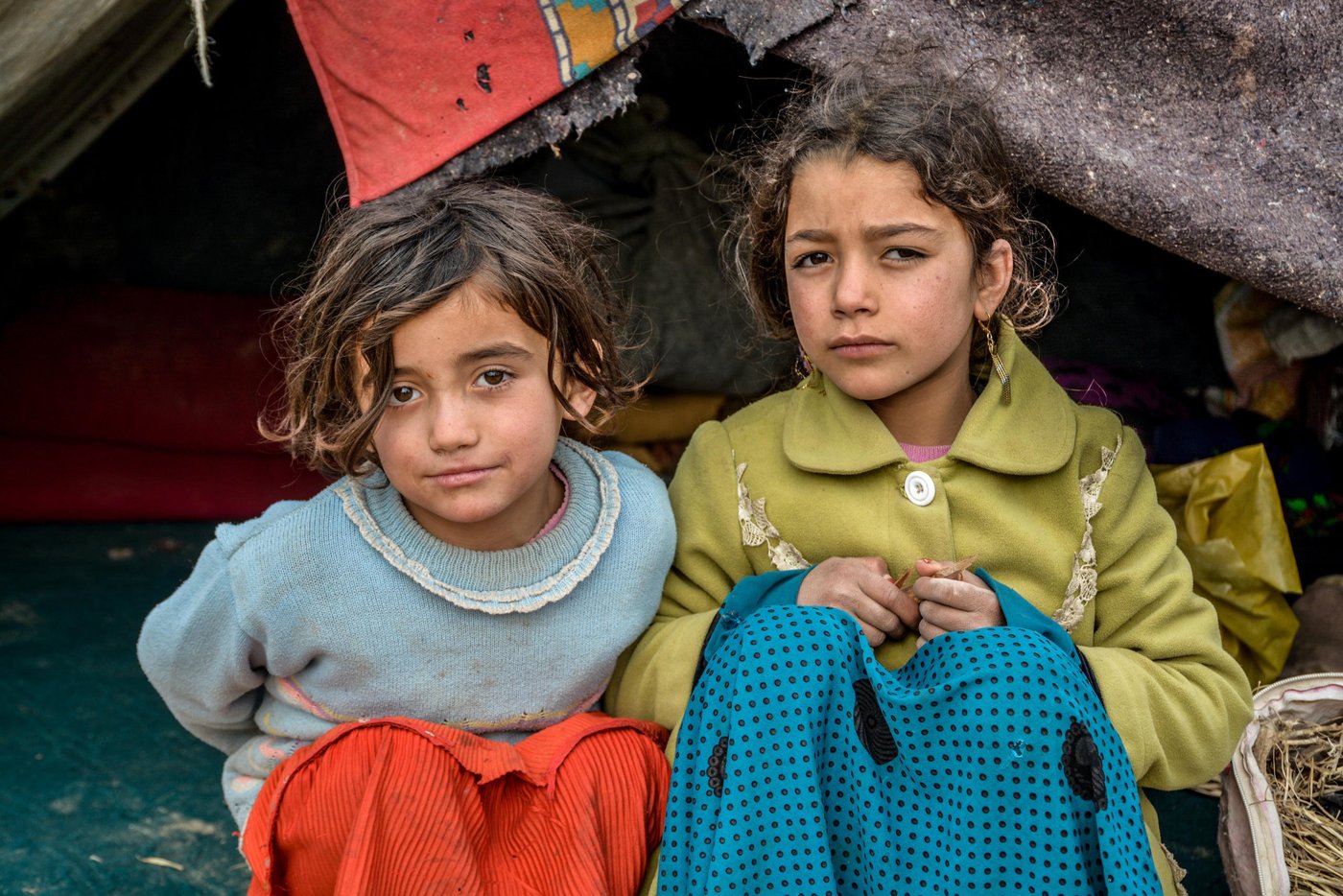 From right to left: Naseema, 9, Gul Ghotay's second daughter and Naseema's friend Latifa (in blue) inside their makeshift home in Feristan IDP settlement. PHoto: NRC/Enayatullah Azad